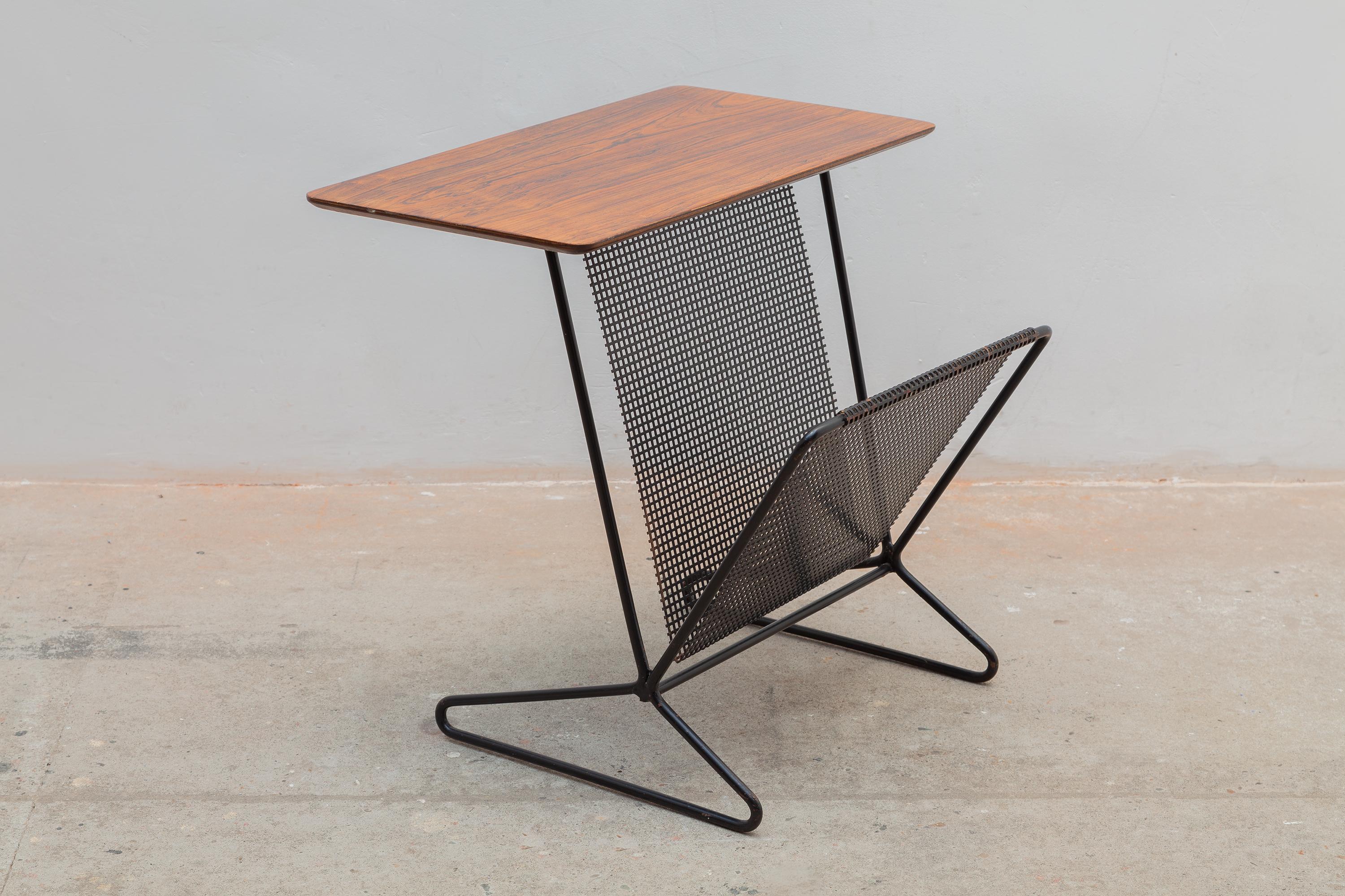 Mid-century magazine table from the Combex Series TM05 designed by Cees Braakman for Pastoe 1954. Sleek walnut top with black wrought metal frame and mesh magazine holder.

Dimensions:55W x 50H x 50D cm.In perfect condition.