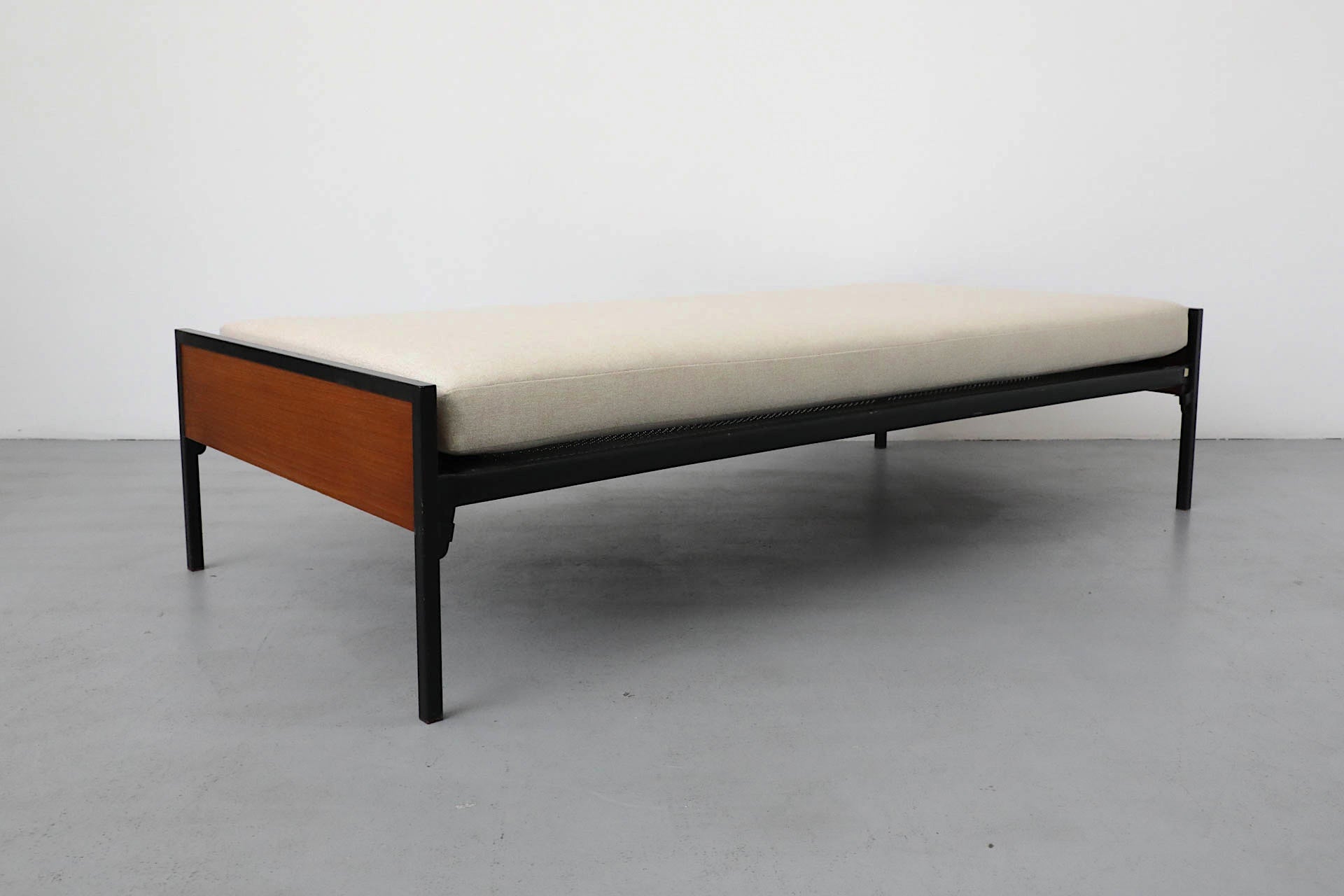 1950's, Dutch Mid-Century, teak and black enameled metal daybed with newly upholstered Castro beige mattress. Bed manufactured by renowned Dutch manufacturer Pastoe and designed by the equally acclaimed designer Cees Braakman. It's frame is in
