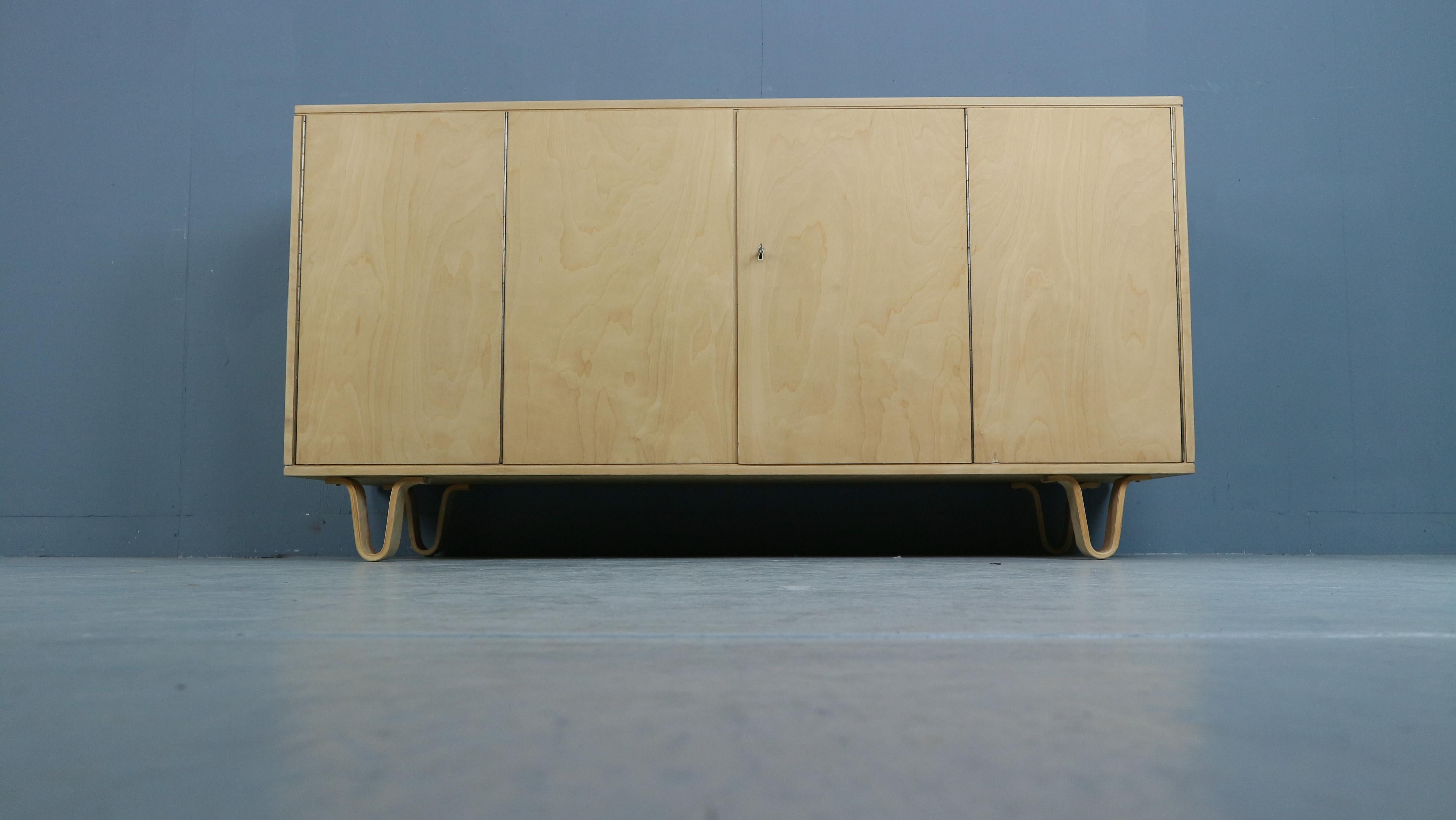 Modernist sideboard model DB02 designed by Cees Braakman, manufactured by Pastoe UMS, Holland 1952. This sideboard has a double folding door with 3 shelves and 4 drawers behind. This sideboard is from the famous birch series by Cees Braakman who