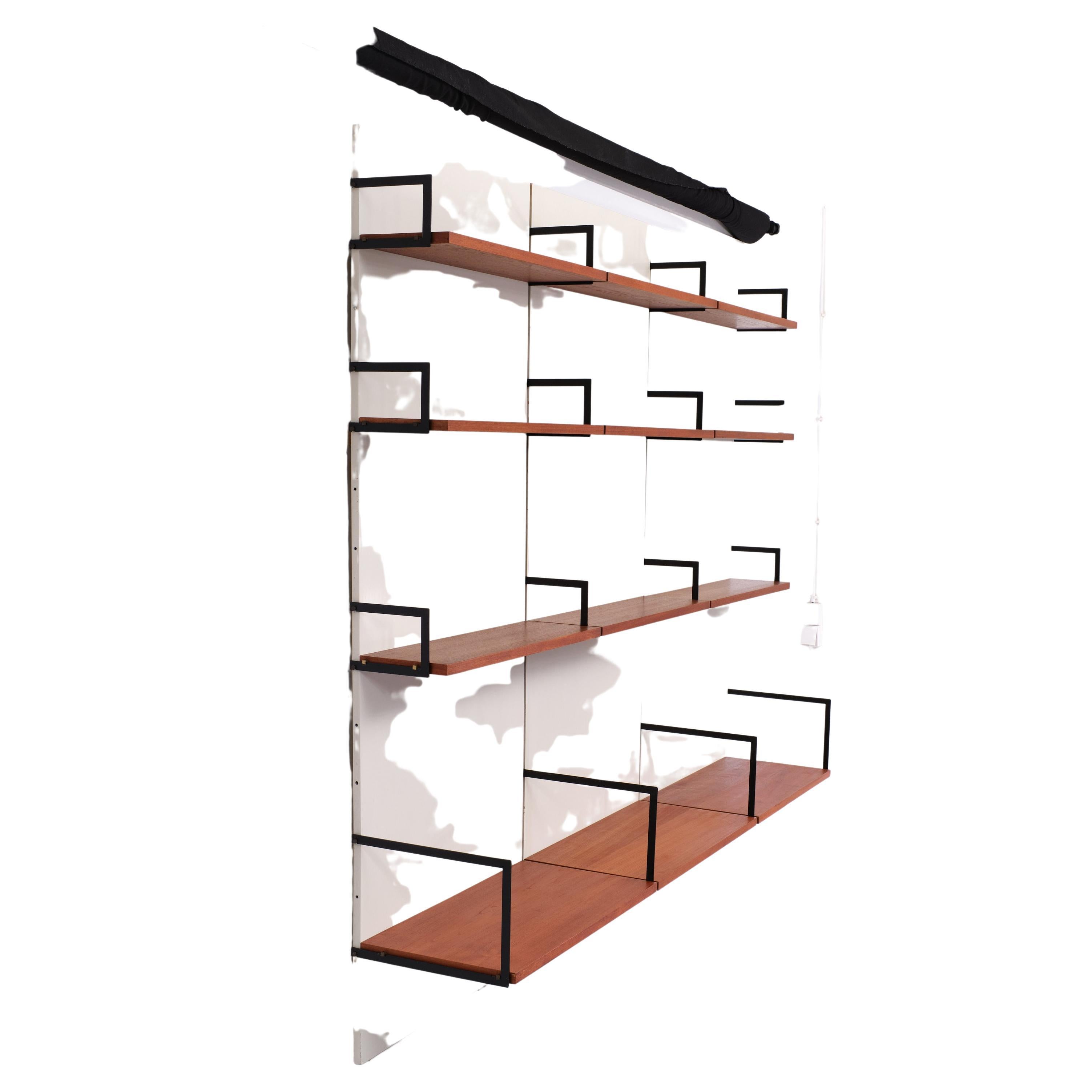 Stunning wall system. Three hanging wall panels in a off white color comes with the original hanging rails. Thirteen teak selves, the three lowest shelves are wider, all the shelves are in a perfect condition. black square shaped brackets and comes