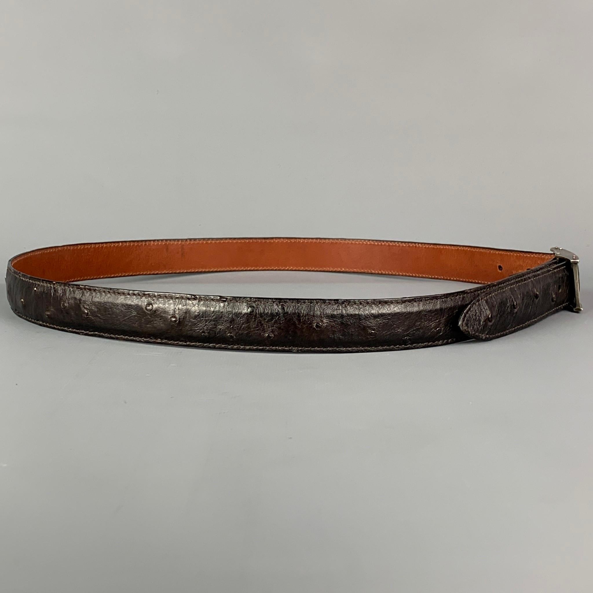 PAT AREIAS belt comes in a black ostrich leather featuring a sterling silver removable buckle. Made in USA. 

Very Good Pre-Owned Condition.
Marked: 36

Length: 43 in.
Width: 1 in.
Fits: 35 in. - 39 in.
Buckle: 2.25 in. 