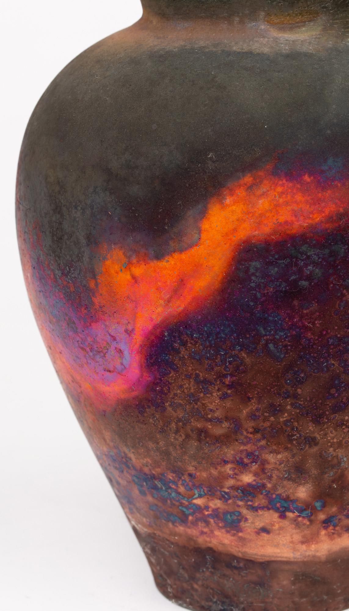 A large and impressive copper fumed raku glazed Studio Pottery vase by British based potter Pat Armstrong and probably dating from the latter 20th century or early 21st century. 
The Raku firing technique creates an unpredictable and unique style on