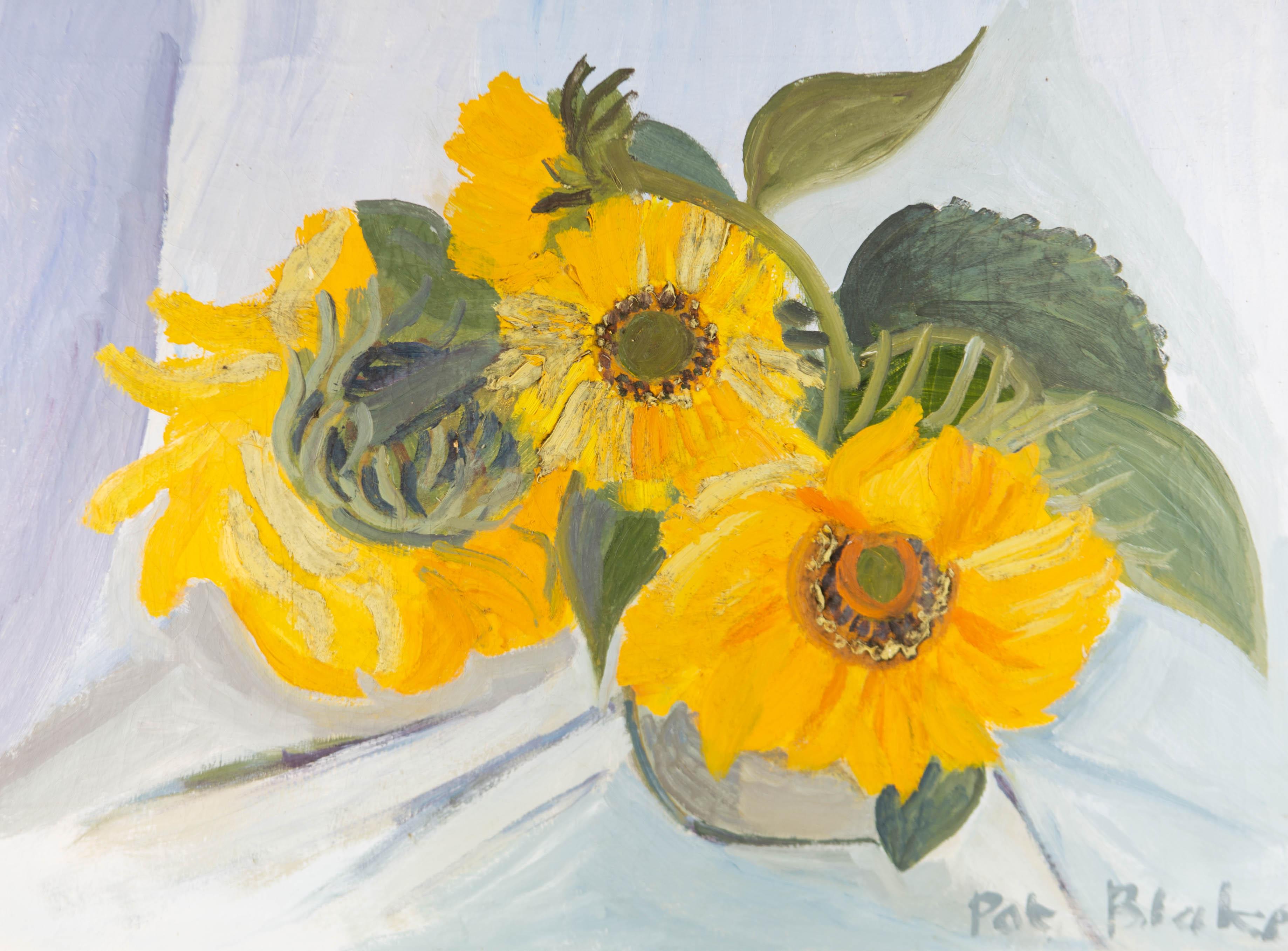 A bright oil painting with areas of impasto by Pat Blake, depicting a still life composition of three sunflowers in a vase. On canvas on stretchers.

