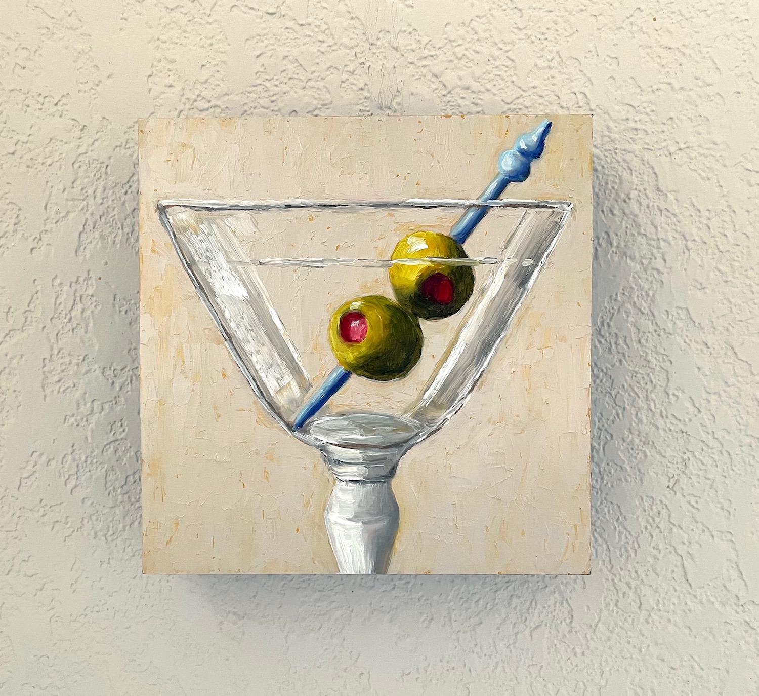 <p>Artist Comments<br>A sleek glass cradles a sophisticated drink. The alcohol reflects a subtle elegance, while the vivid green olives and a contrasting blue skewer add a burst of color against the beige background. The artwork emphasizes a
