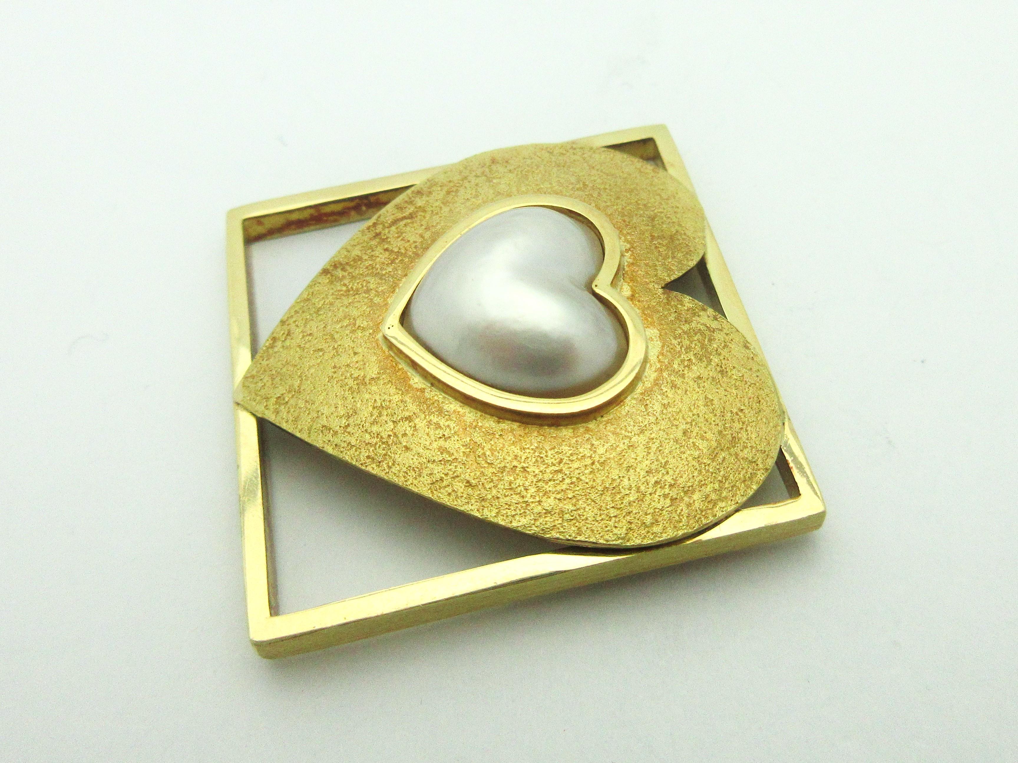We are thrilled to offer this highly collectible Pat Flynn heart pin!  

The pin is made from 18k yellow gold, featuring a textured heart set with a heart-shaped mabe pearl in a polished square frame.  The pin measures 1.25