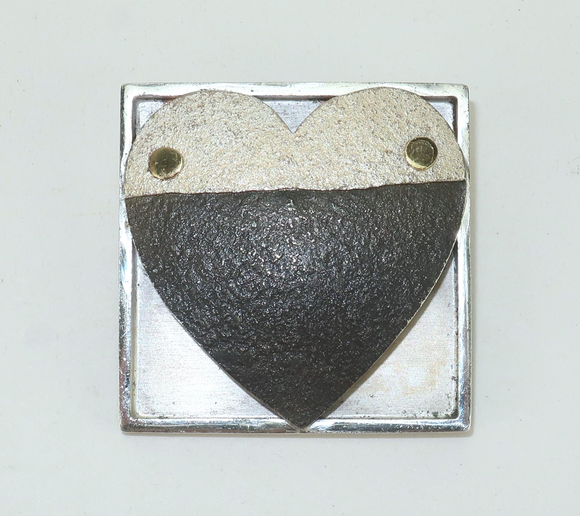 The heart pin tells a story as Pat Flynn, New York goldsmith, intended with his iconic contemporary design.  Mr. Flynn's hearts have been a constant in his repertoire of modernist jewelry and this sterling silver, nickel and 18K gold hand wrought