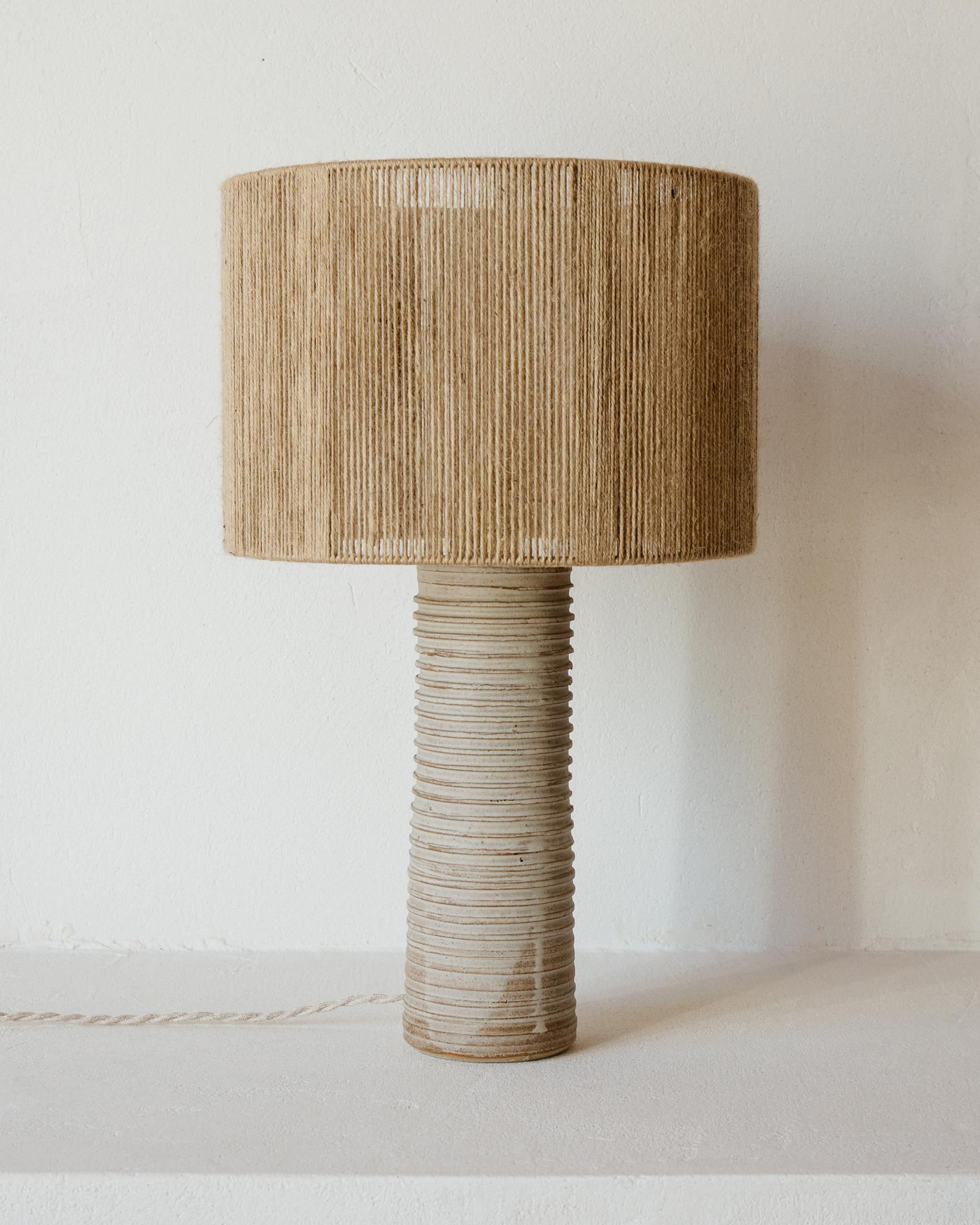 Lampe à poser en céramique mate blanc gris Patagonia par Grès Éditions
Pièce unique.
Dimensions : Abat-jour : Ø 30 x H 22 cm.
Base : H 30 cm.
MATERIAL : Jute et céramique.
Poids : 2,6 kg.

Système électrique : câble électrique tissé en lin (longueur