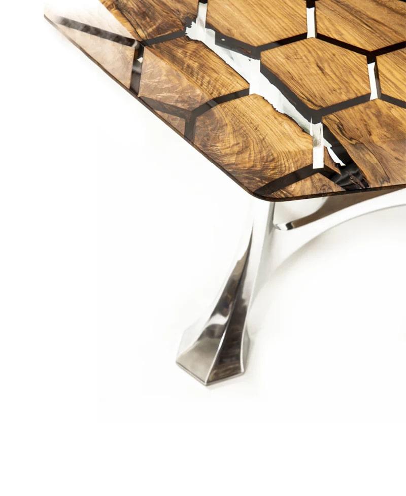 Dieser atemberaubende Tisch ist eine perfekte Mischung aus Kunst und Technik. Er zeigt eine faszinierende sechseckige Holzintarsie, die nahtlos mit kristallklarem Harz und poliertem Edelstahl kombiniert ist. Das komplizierte geometrische Muster hebt