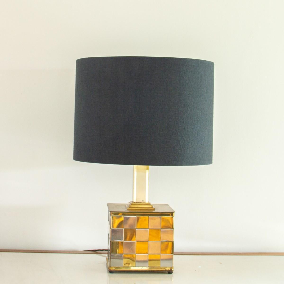 A brass and chrome checkerboard/patchwork cube shaped lamp, with a chunky brass stem and set on small brass feet, 1970s

Light tarnishing all-over with slightly heavier tarnishing towards the base.

Base measurements are 21.5cms square.
  