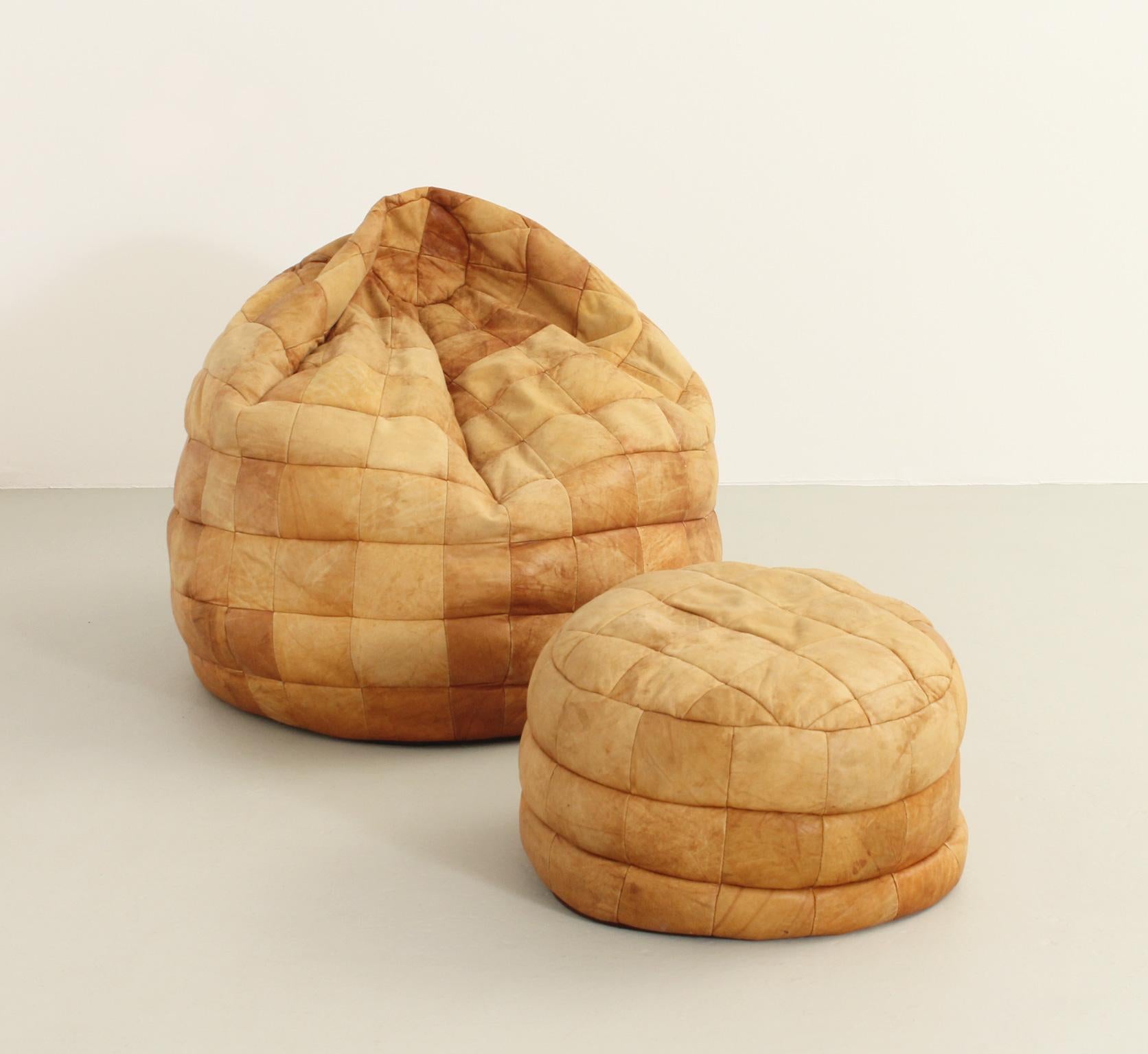 Leather bean bag and ottoman by De Sede, Switzerland, 1970's. Patchwork leather filled with polystyrene balls that conforms to the shape of the body.

Dimensions: 95 Ø x 80 H. cm. Seat and 58 Ø x 38 H. cm. Ottoman.