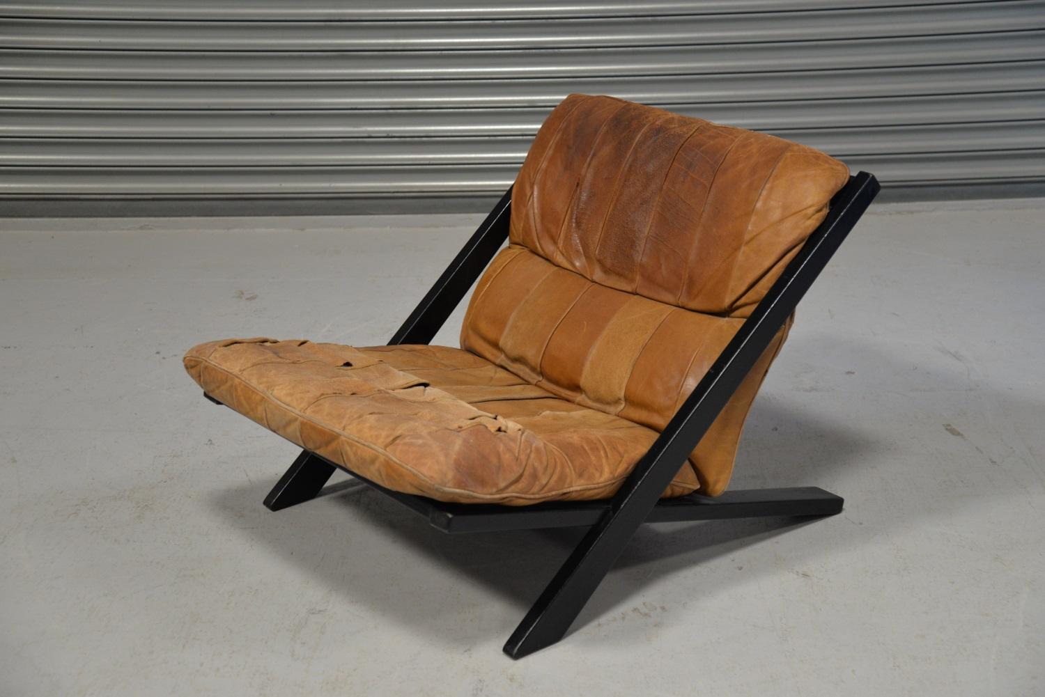 We are delighted to bring to you an original patchwork leather lounge chair by Ueli Berger for De Sede of Switzerland, 1970s. Standing on a black lacquered wooden frame with tan patchwork leather. As you will see from the images this chair has seen