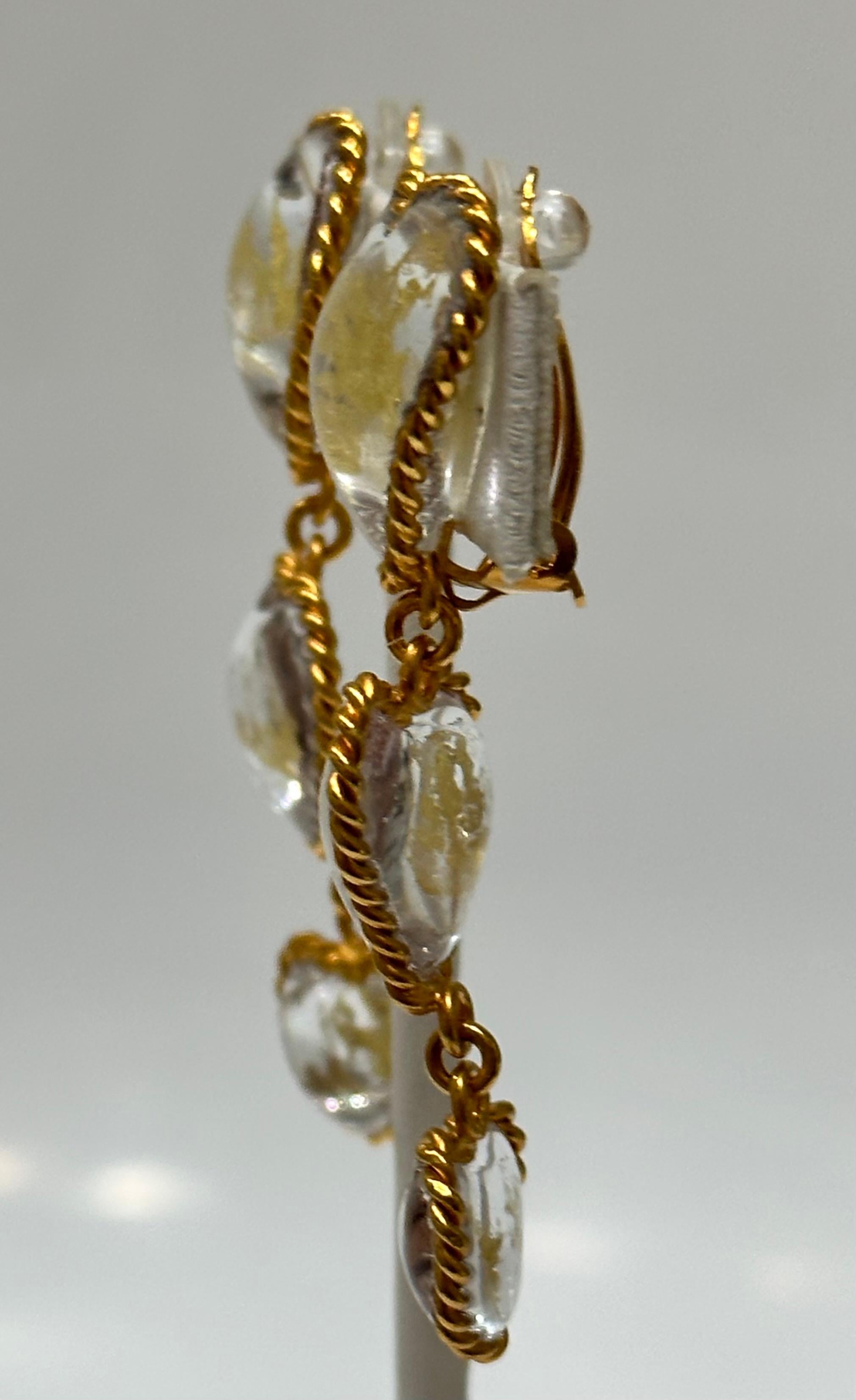 Masterfully crafted poured glass clip earrings, clear with gold leaves inserted, from Pate de Verre Collection.  

Designed by a former artisan of the Atelier de GRIPOIX in the savoir faire used for all the Chanel pieces they executed.
This is a