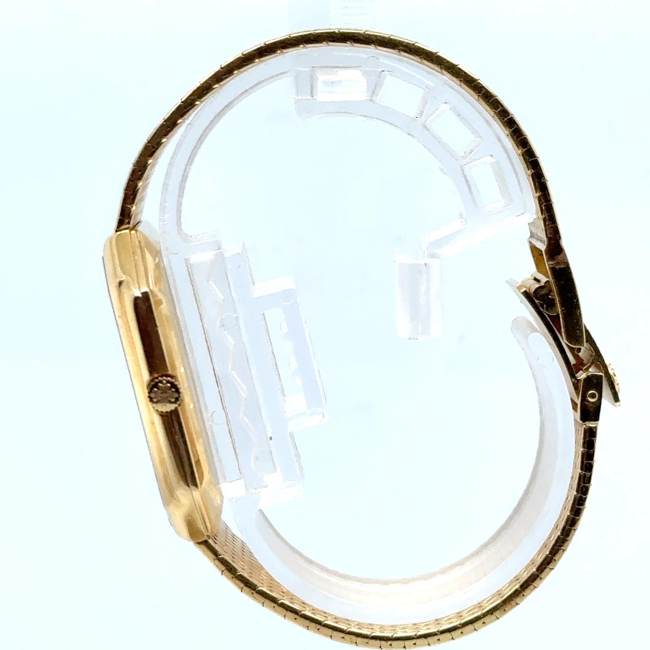 Cette exceptionnelle montre à quartz d'occasion Patek Philippe en or jaune 18 carats présente un cadran blanc de 30 mm sur un bracelet en or assorti, d'une longueur de 7 pouces et d'un poids total de 92,4 grammes, mettant en valeur l'artisanat