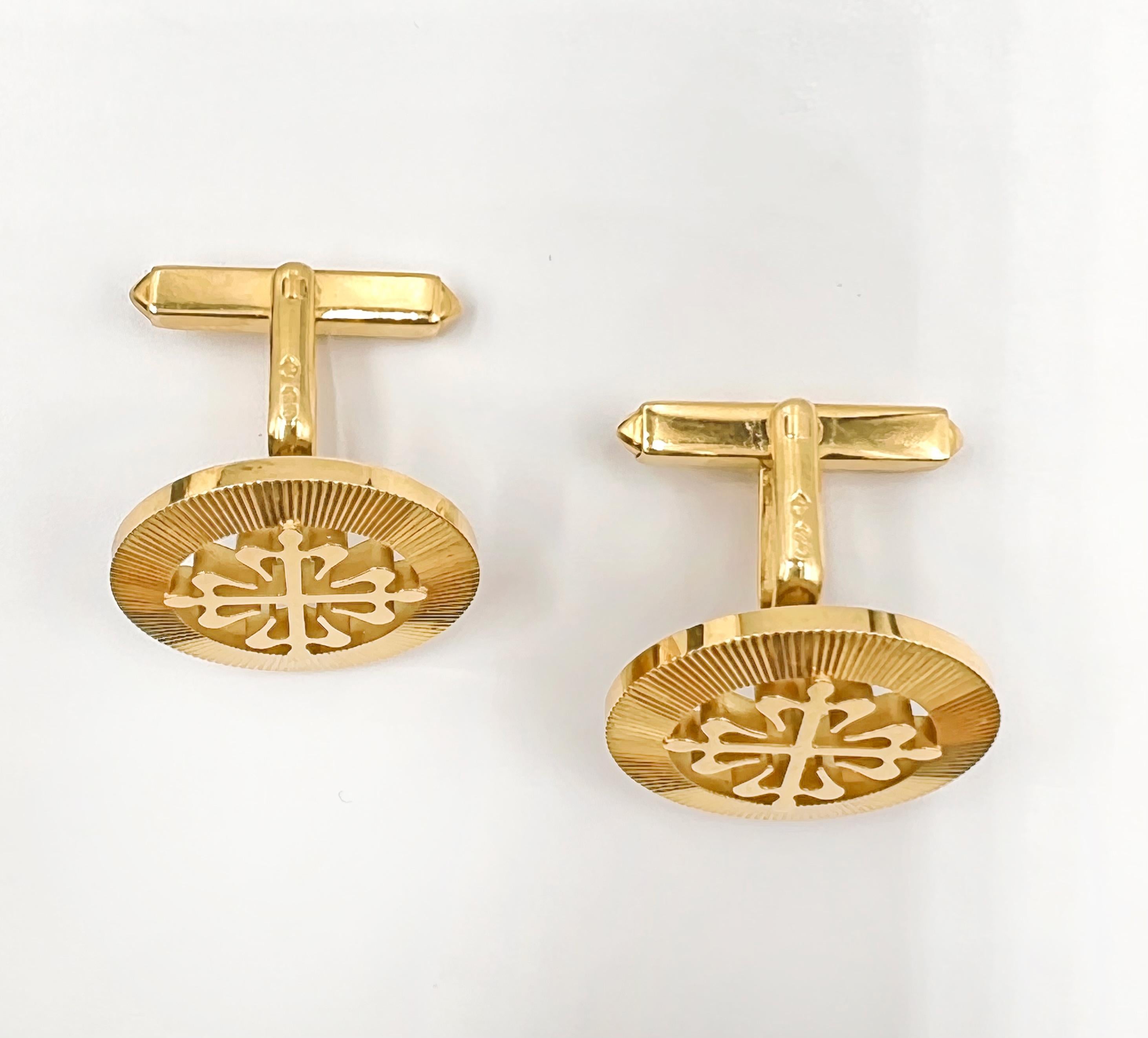 Pair of Patek Philippe 18k yellow gold Calatrava cufflinks, featuring a circular design with a fluted bezel style border and a central cut-out and polished Calatrava Cross design.  Swivel bar on the reverse to fit inside the shirt cuff.  Signed