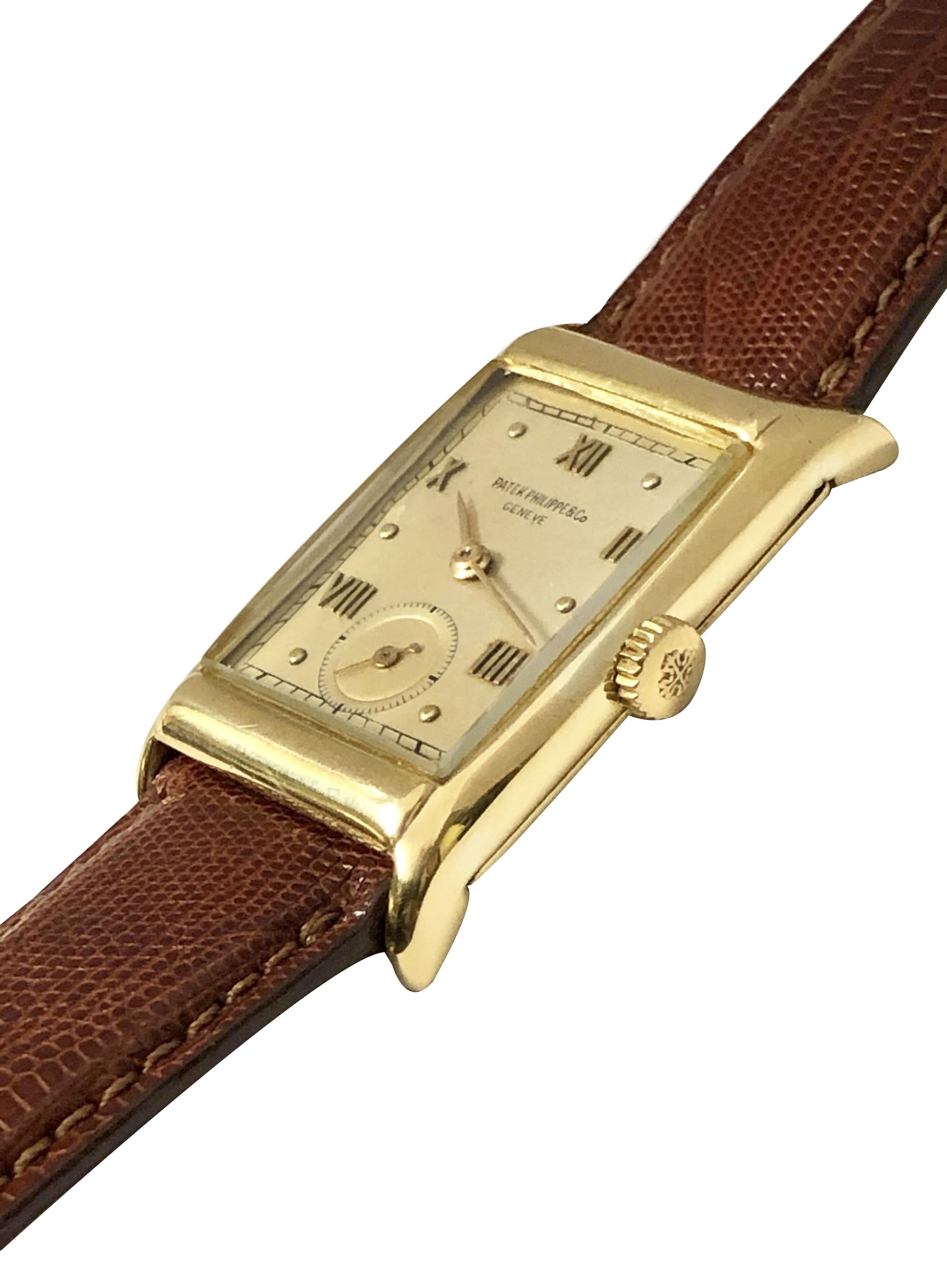 Circa 1940s Patek Philippe Wrist watch, 40 X 24 M.M. 2 Piece 18K yellow Gold case. 18 Jewel Mechanical, Manual wind nickle lever movement. Patek Philippe Logo crown, Silver Satin dial with raised Gold markers. New Hadley Roma Brown Lizard strap,