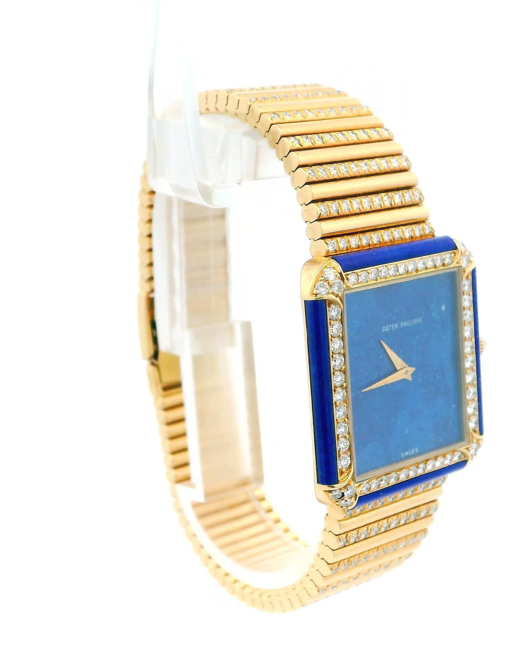 This is an 18k yellow gold gentlemen's dress wristwatch featuring a rare lapis lazuli dial. It has a fixed 18k yellow gold bezel set with lapis and 54 round brilliant-cut diamonds. The watch includes an 18k yellow gold jewelry-style bracelet adorned