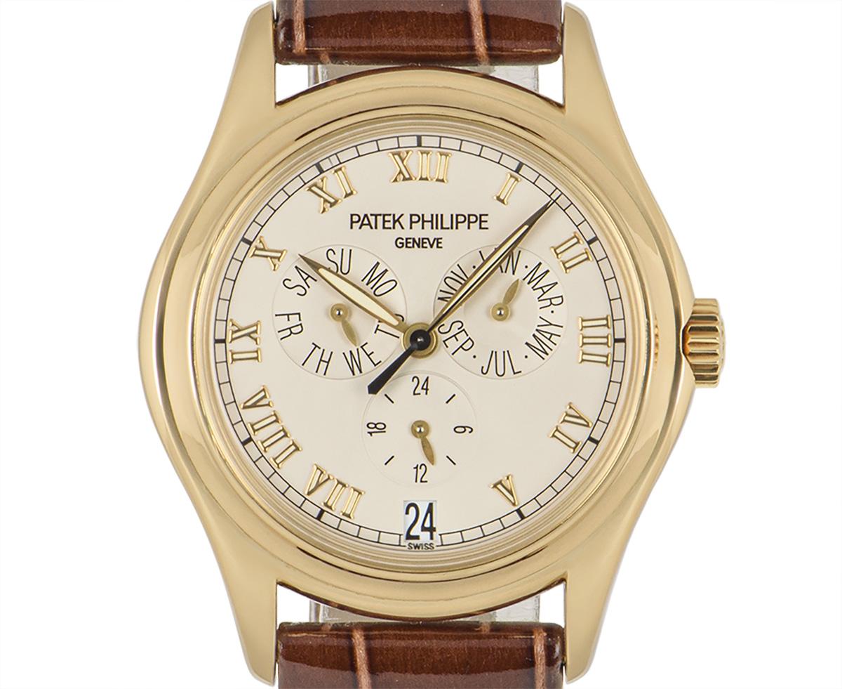 A 37 mm Annual Calendar in yellow gold by Patek Philippe. Its silver dial concealed with sapphire crystal features a day, date and month display as well as a 24-hour display. A generic brown leather strap is accompanied by an original yellow gold