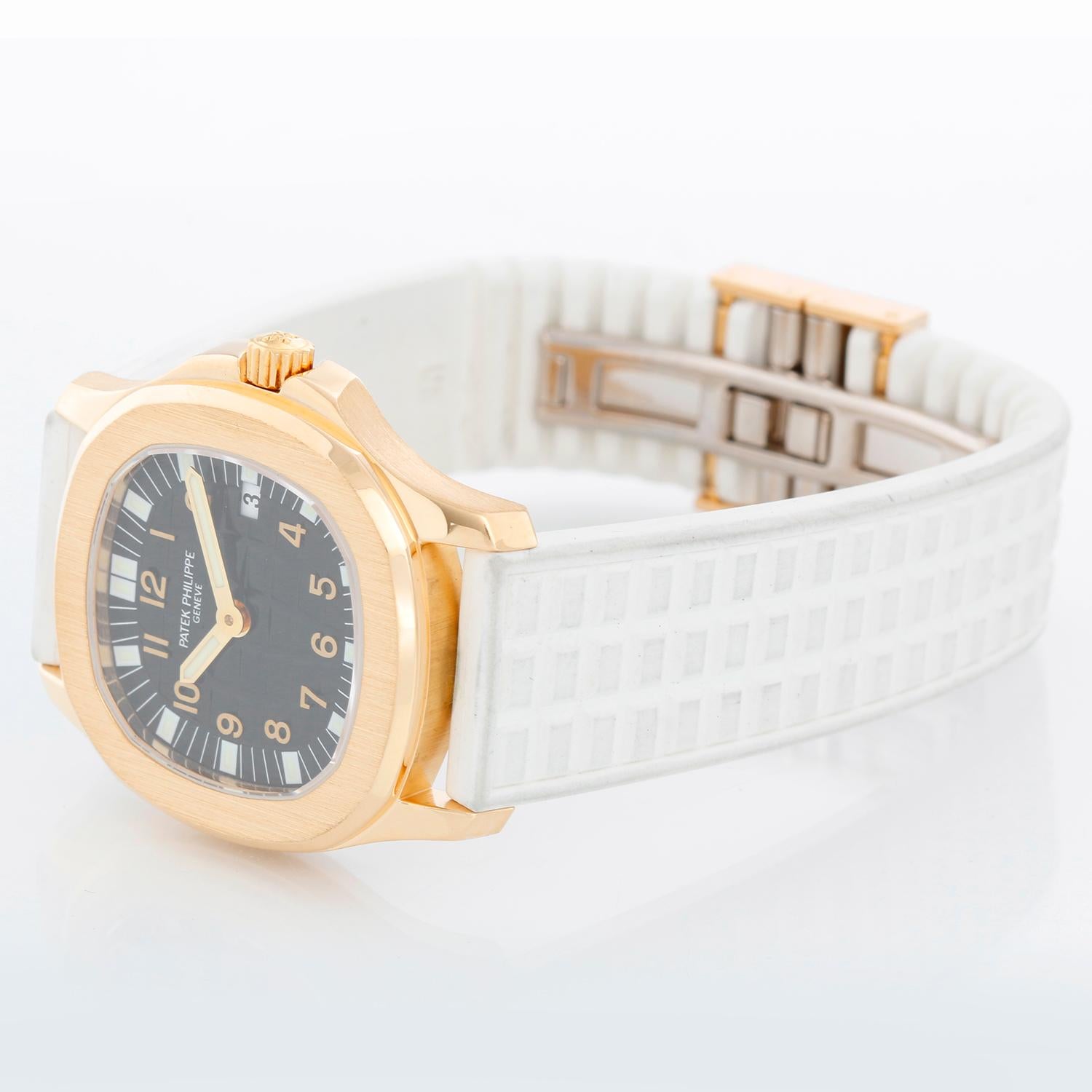 Patek Philippe Aquanaut 18K Yellow Gold Watch 4960 J - Quartz. 18K Yellow gold ( 30 mm ). Black dial with Arabic numerals. White rubber strap  band with 18k yellow gold Patek Philippe deployant clasp. Pre-owned with Patek box .
