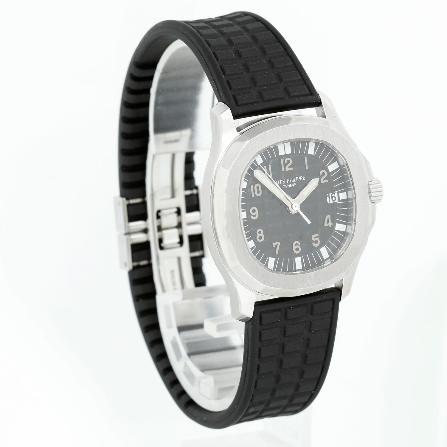 Patek Philippe Aquanaut Men's Steel Watch 5064A - Automatic winding. Stainless steel case with exposition back (34mm diameter). Black waffle dial with Arabic numerals and luminous markers; date at 3 o'clock. Black rubber strap band with stainless
