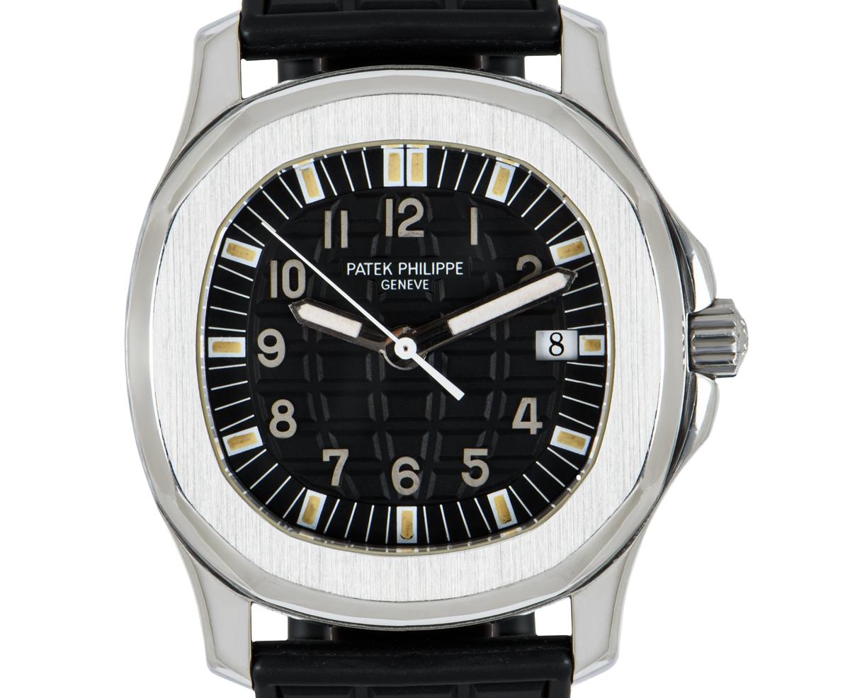 A 36 mm stainless steel mid-size Aquanaut by Patek Philippe, featuring a black embossed dial with a date display at 3 o'clock. An original black rubber strap is equipped with a double deployant clasp. Fitted with sapphire crystal and a quartz