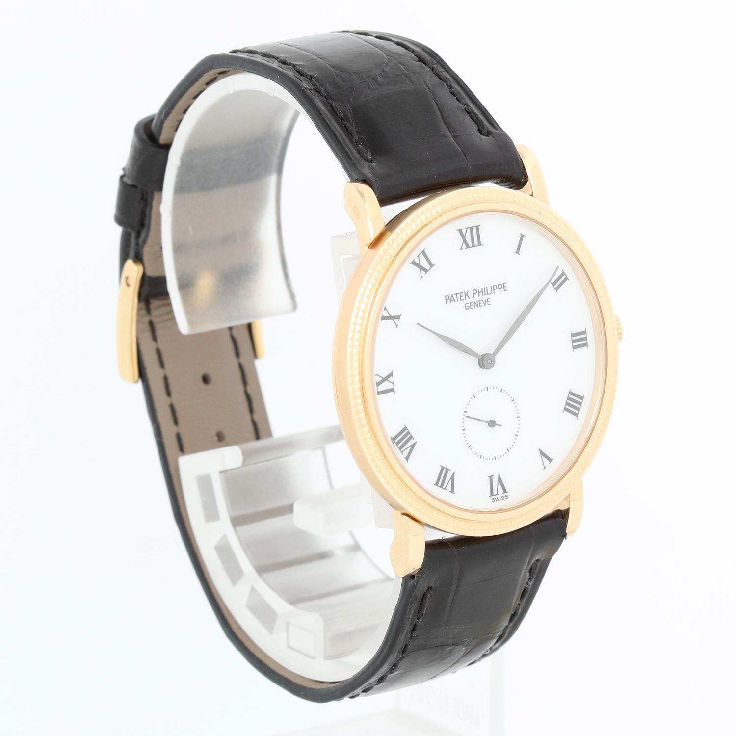 Patek Philippe Calatrava 18k Yellow Gold Men's Watch 3919 - Manual winding. 18k yellow gold case with hobnail bezel (32mm diameter). White dial with roman numerals. Patek Philippe strap with Patek Phillippe yellow gold tang buckle  . Pre-owned with