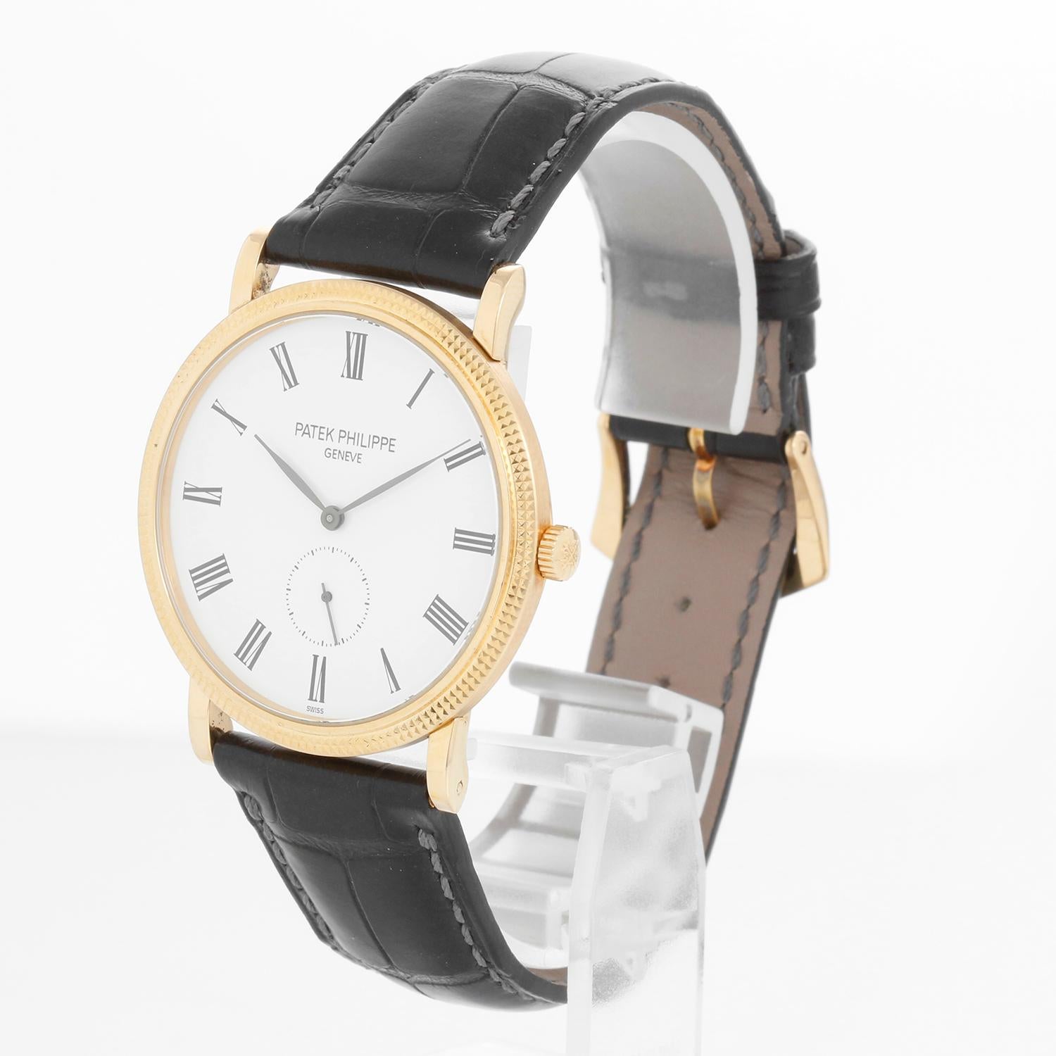 Patek Philippe Calatrava 18k Yellow Gold Men's Watch  5119-J (or 5119J-001) - Manual winding. 18k yellow gold case with hobnail bezel and exposition back (36mm diameter). White dial with black Roman numerals; subseconds at 6 o'clock. Black Patek