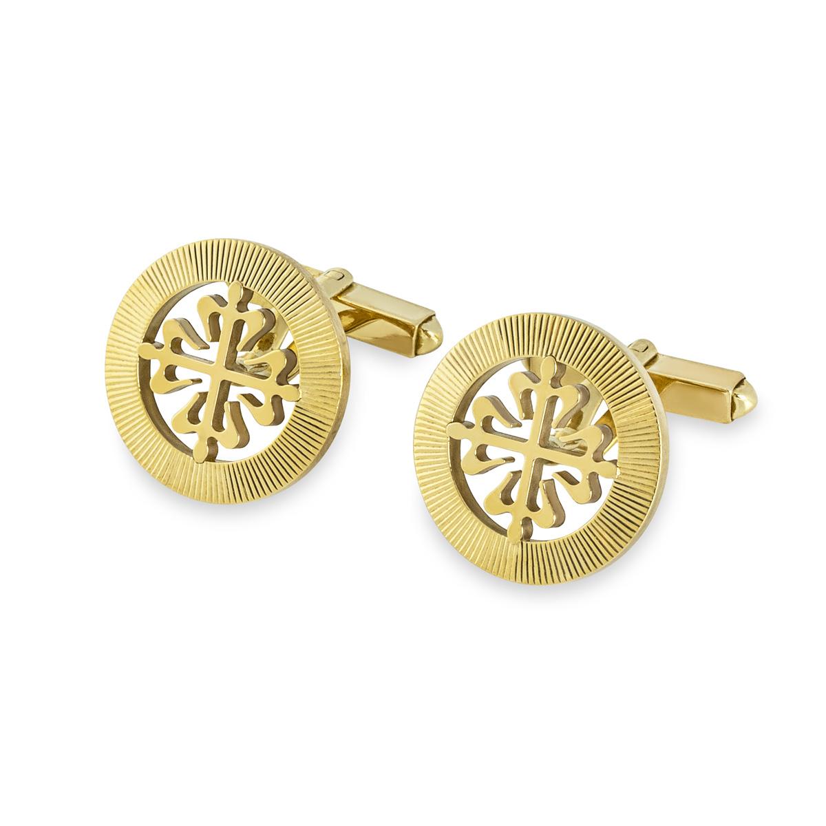 A pair of Calatrava cufflinks in 18ct yellow gold by Patek Philippe. Each cufflink features the classic Calatrava cross motif, surrounded by a guilloched outer ring. Featuring t-bar fittings, the Calatrava motif measures 18mm in diameter. The