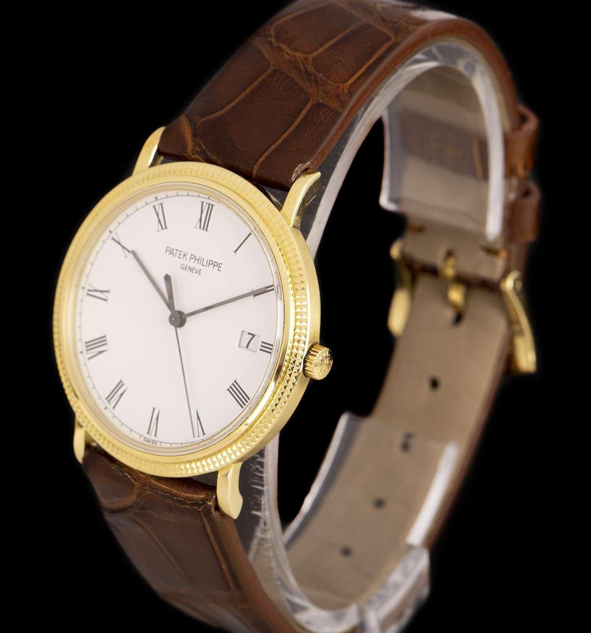 An 18k Yellow Gold Calatrava Gents 33mm Wristwatch, white porcelaine dial with roman numerals, date at 3 0'clock, a fixed 18k yellow gold hobnail bezel, a brown leather strap (not by Patek Philippe) with an original 18k yellow gold pin buckle,