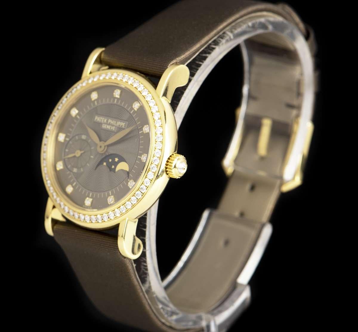 An 18k Yellow Gold Calatrava Ladies Wristwatch, brown dial set with 12 applied round brilliant cut diamond hour markers, moonphase aperture at 4 0'clock, small seconds between 8 and 9 0'clock, a fixed 18k yellow gold bezel set with approximately 61