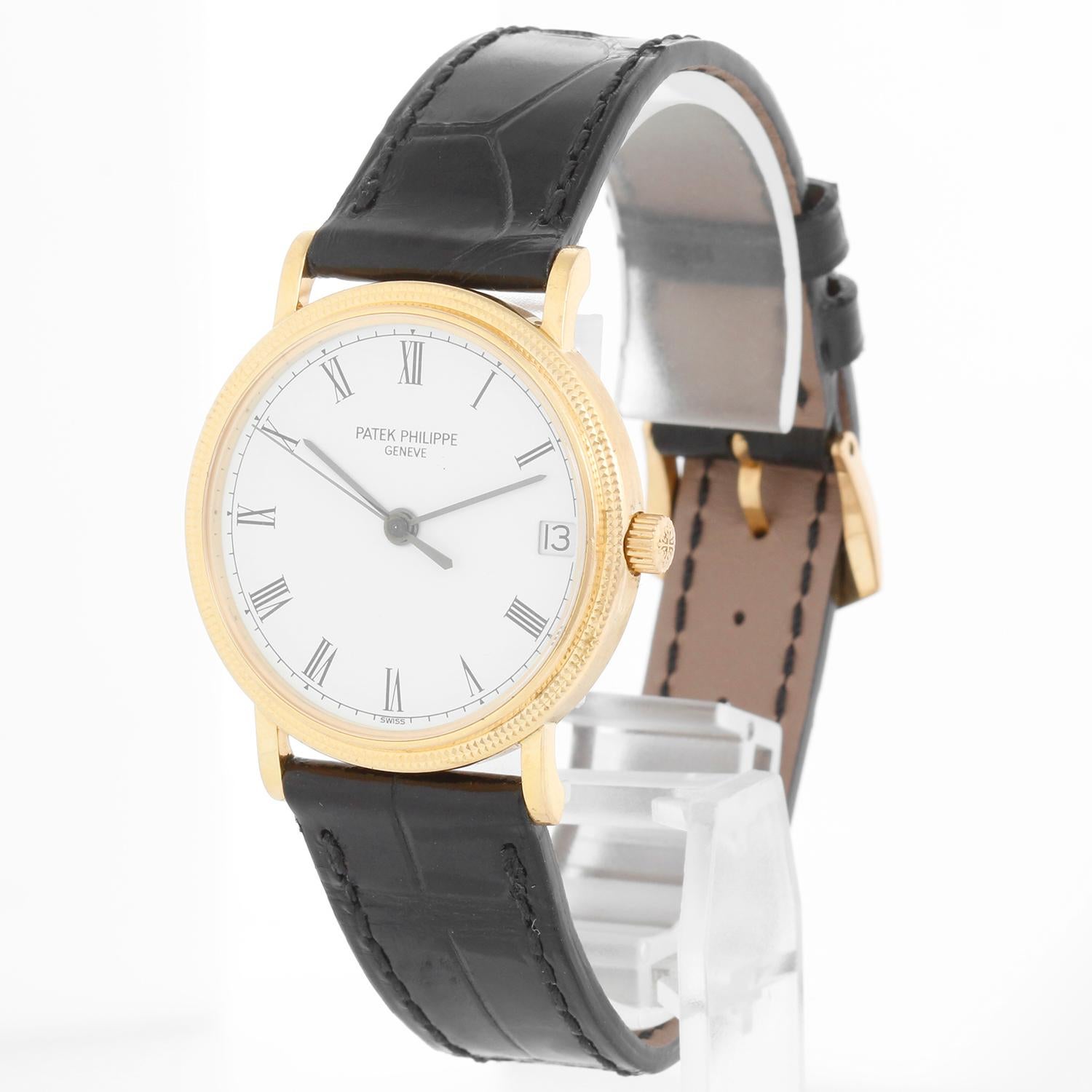 Patek Philippe Calatrava Ref. 3802/200 Montre Homme Hobnail  - Automatique. Boîtier en or jaune 18 carats avec finition hobnail (33 mm). Cadran blanc avec aiguilles bâton noires, index chiffres romains noirs. Bracelet en cuir noir Patek Philippe