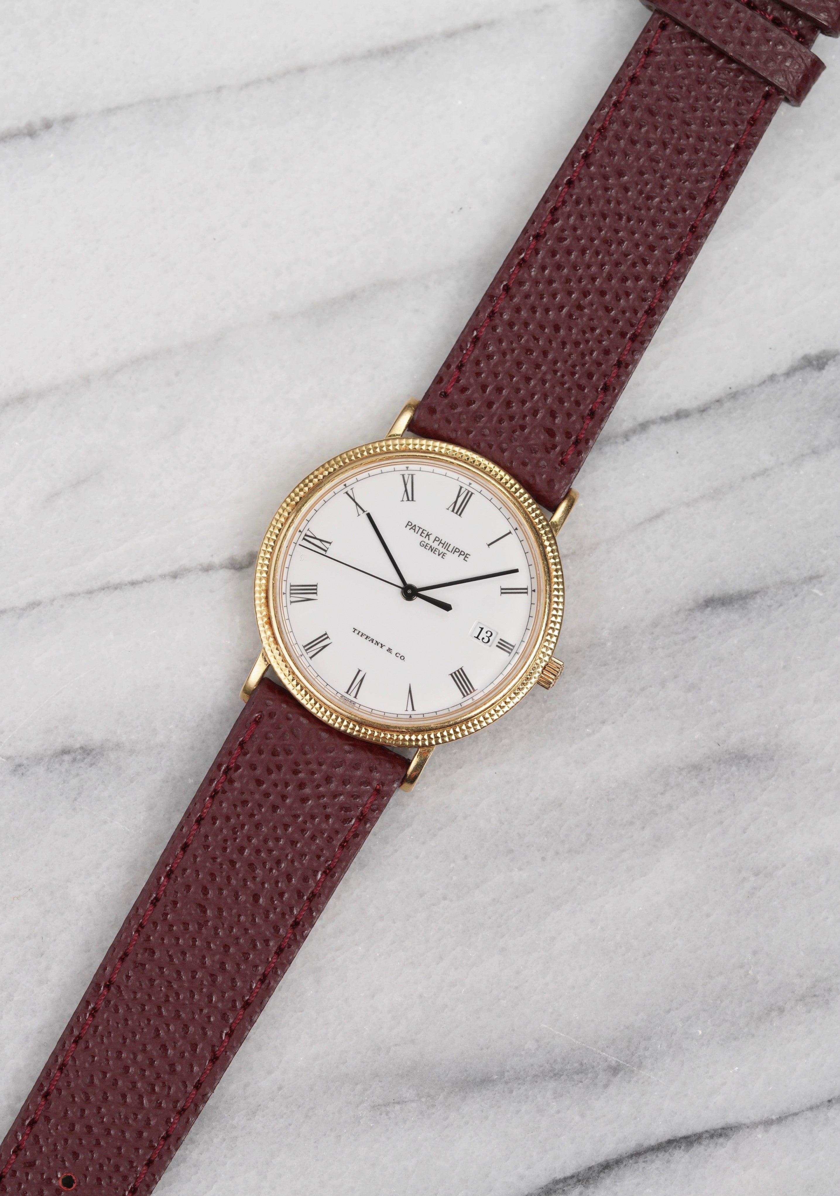 Here’s a Patek Philippe Calatrava quartz white roman numeral dial from the 1990s featuring a Tiffany stamp at 6 o'clock. Measurements include a 34mm case and 18mm lug width. On an aftermarket maroon pebble textured leather strap (Made in Italy).