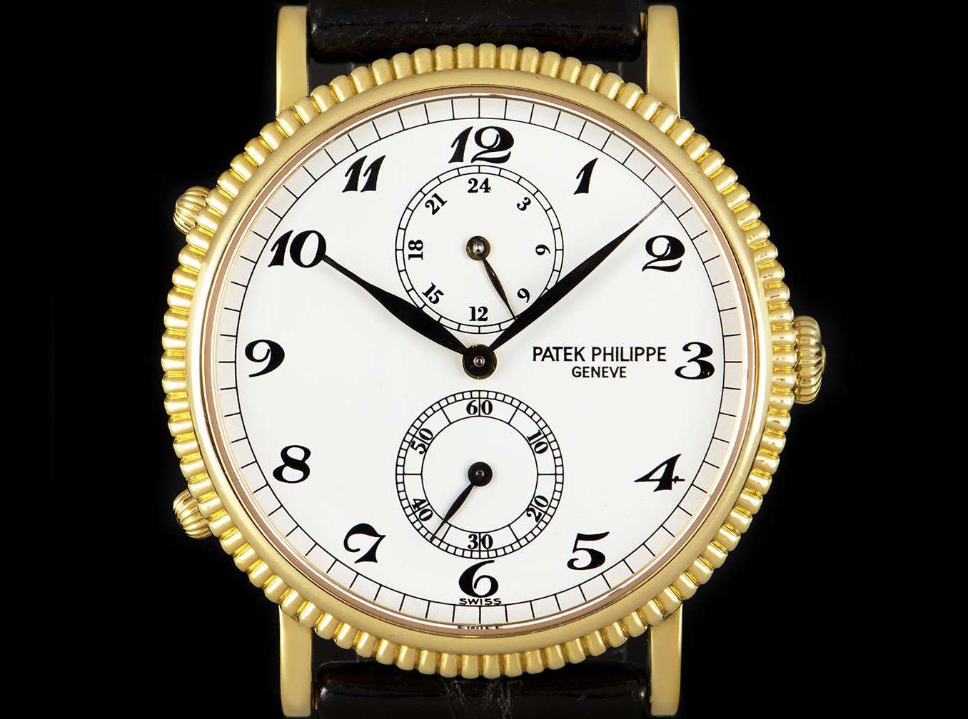 An 18k Yellow Gold 34mm Calatrava Travel Time Men's Wristwatch, white dial with arabic numbers, small seconds at 60'clock, 24 hour indicator at 120'clock, a fixed 18k yellow gold reeded bezel, an original black leather strap with an original 18k