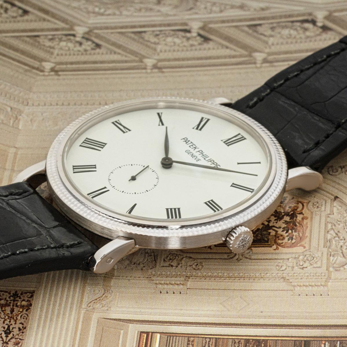 A timeless 36mm Calatrava in white gold by Patek Philippe. Features a lacquered white dial with Roman numerals and a small seconds display at 6 o'clock. The original Patek black leather strap comes with an original Patek white gold pin buckle.