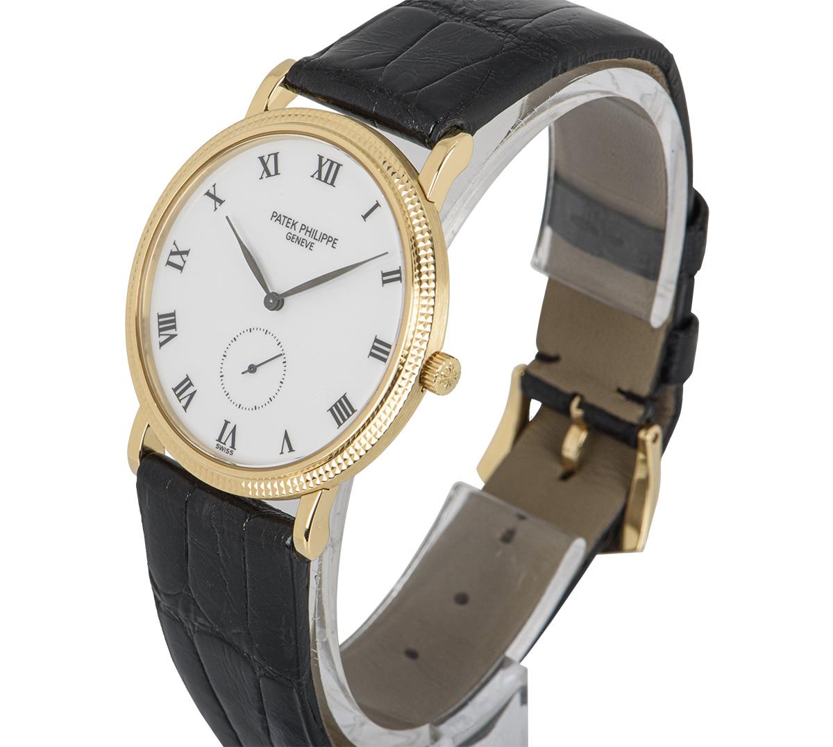 A 33 mm 18k Yellow Gold Calatrava Men's Wristwatch, porcelain white dial with roman numerals, small seconds at 6 0'clock, a fixed 18k yellow gold hobnail bezel, a black leather strap with an original 18k yellow gold pin buckle, sapphire glass,