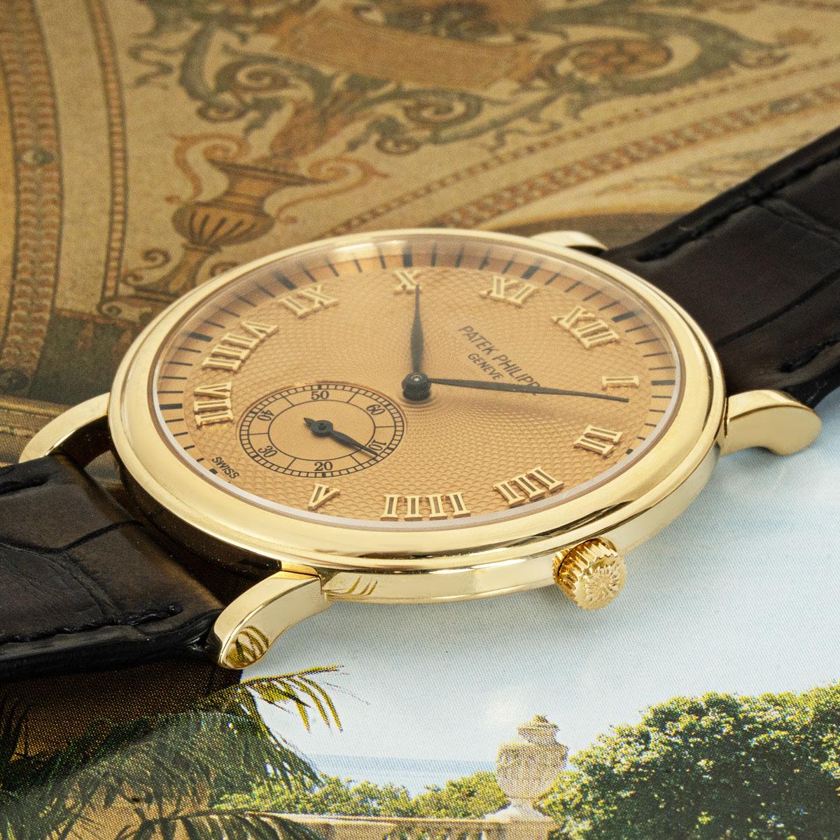 A yellow gold 33mm Patek Philippe Calatrava. Featuring a champagne dial with roman numerals and a small seconds sub-dial complemented by a yellow gold bezel.

Fitted with a sapphire glass, a manual wind movement and a dark brown Patek Philippe