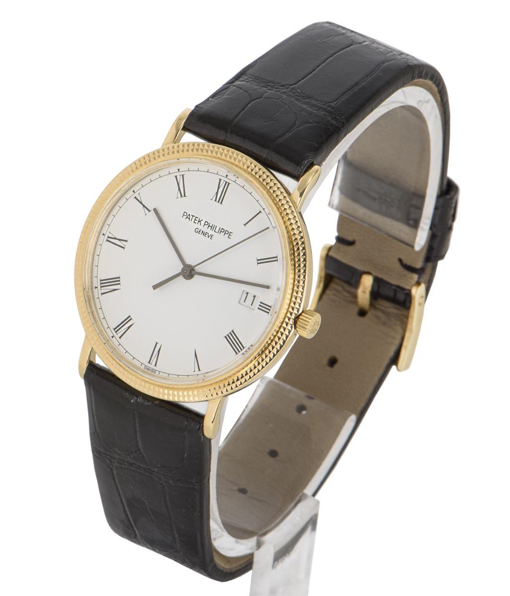 A 33 mm yellow gold Calatrava by Patek Philippe, featuring a porcelain white dial with Roman numerals and the date displayed at 3 o'clock. The generic black leather strap comes with an original yellow gold pin buckle. Fitted with sapphire crystal
