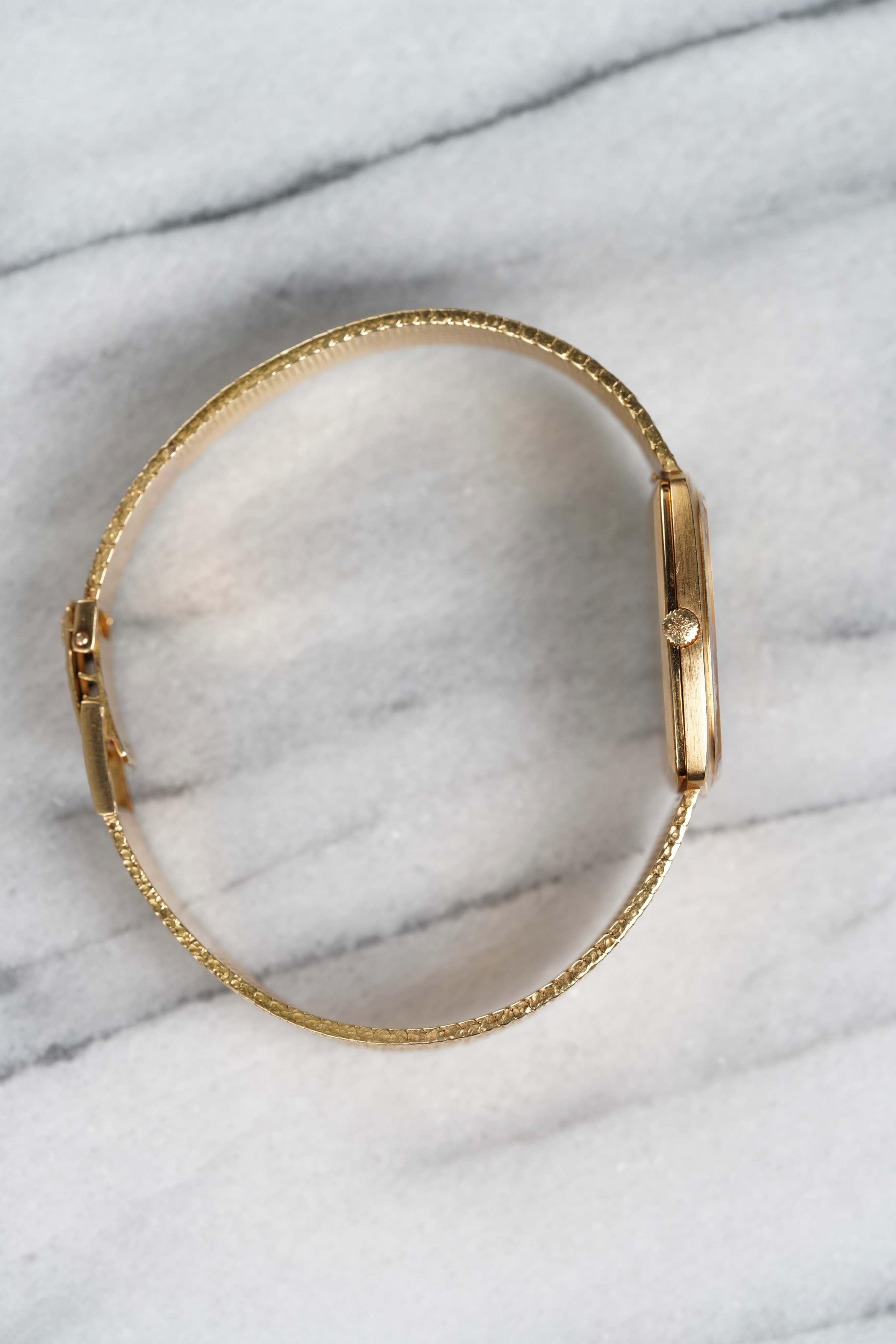 Nos complace presentar una pieza realmente destacada de la época de diseño más audaz de Patek Philippe: la Ref. 3567 en oro amarillo de 18 quilates, con una esfera rara de color champán con acabado martillado y un brazalete de oro martillado a