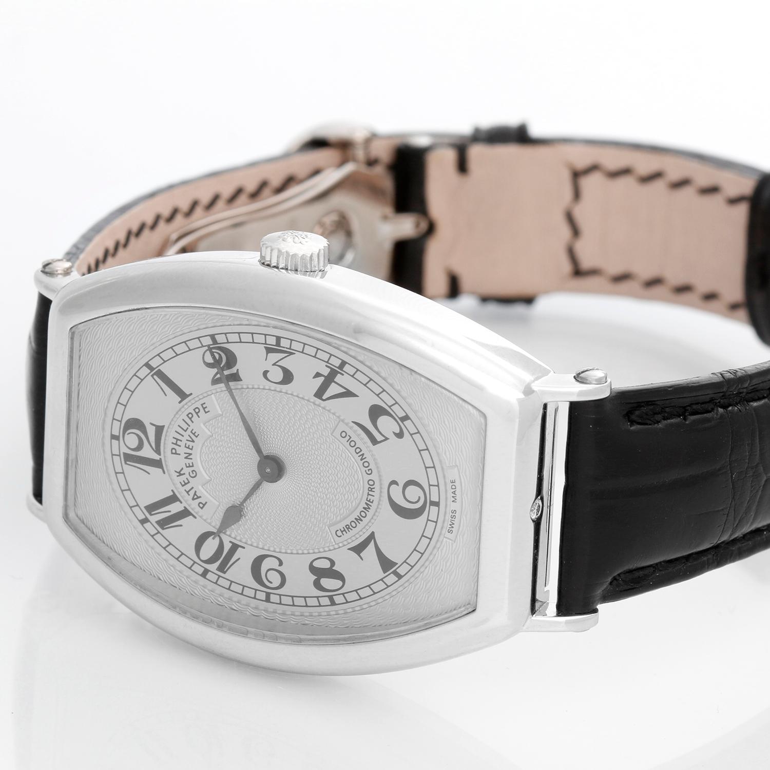 Patek Philippe Chronometro Gondolo Platinum Men's Watch  5098 P (or 5098P) - Manual winding. Platinum tonneau shaped case with exposition back (32mm x 50mm). Silver guilloche dial with black Arabic numerals. Black  Patek Philippe strap band and