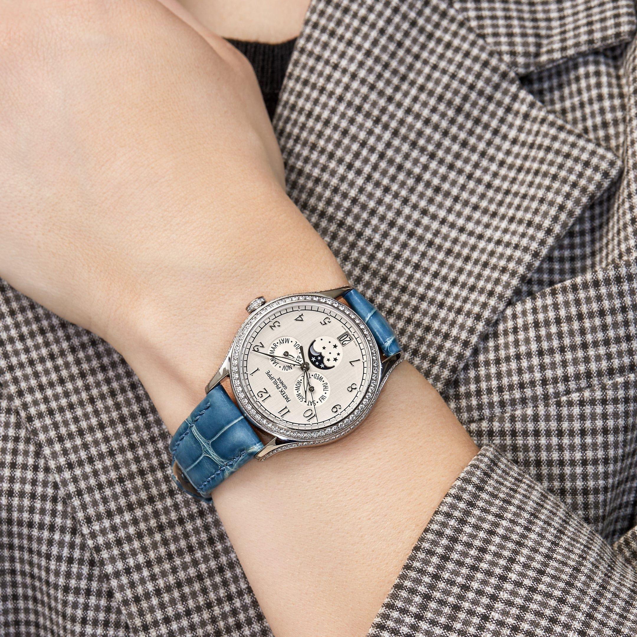 This Patek Philippe Complications Annual Calendar is crafted in a white gold 38mm case, surrounded by an exquisite diamond set bezel. The silky silver dial delivers femininity and function, as it features day, month, and moon phase timekeeping