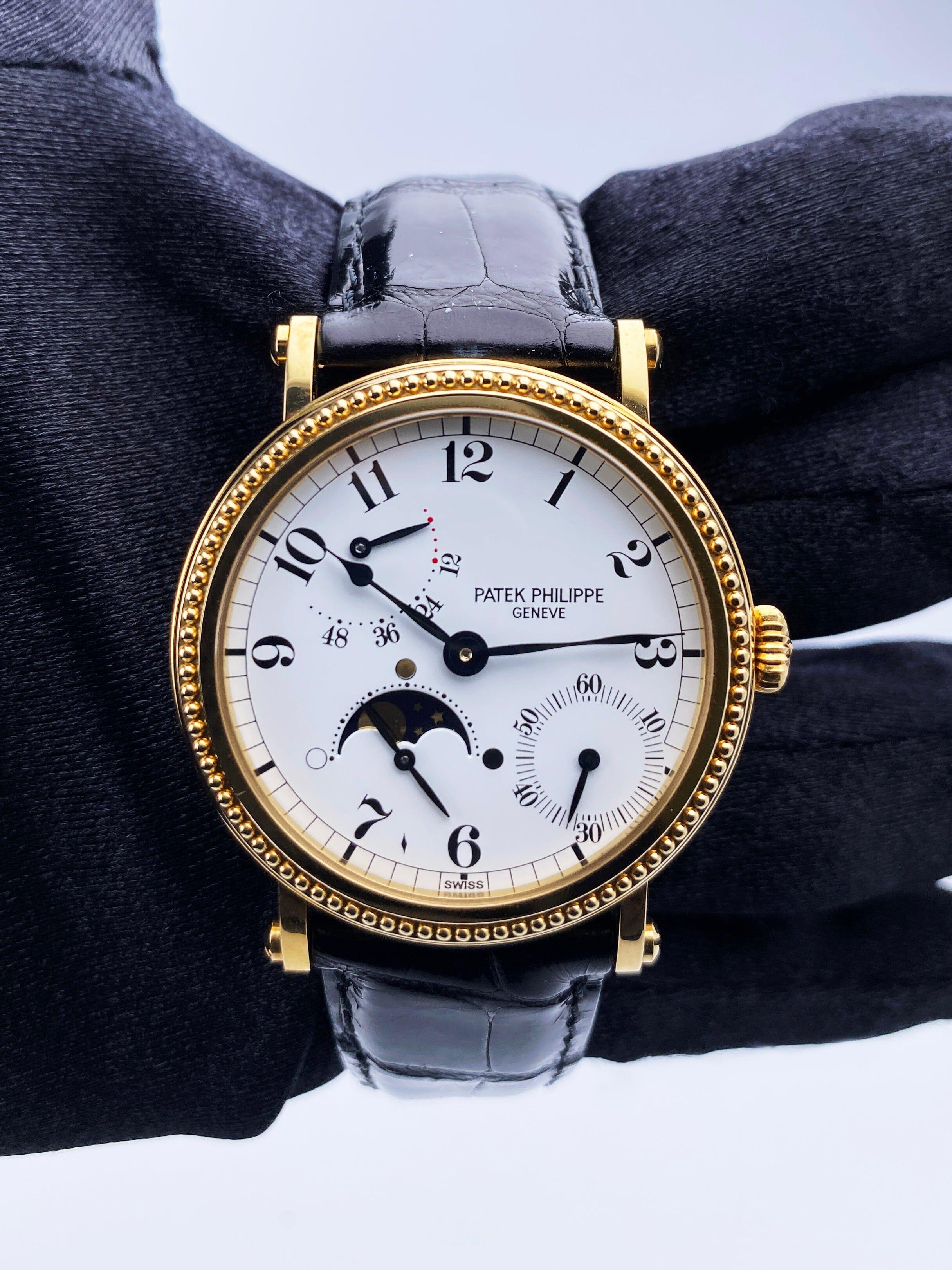 Reloj Patek Philippe Complications para caballero. Caja de 35 mm de oro amarillo de 18 quilates y bisel de oro amarillo de 18 quilates. Esfera blanca con agujas negras e índices con números arábigos. Visualización del indicador de fase lunar entre