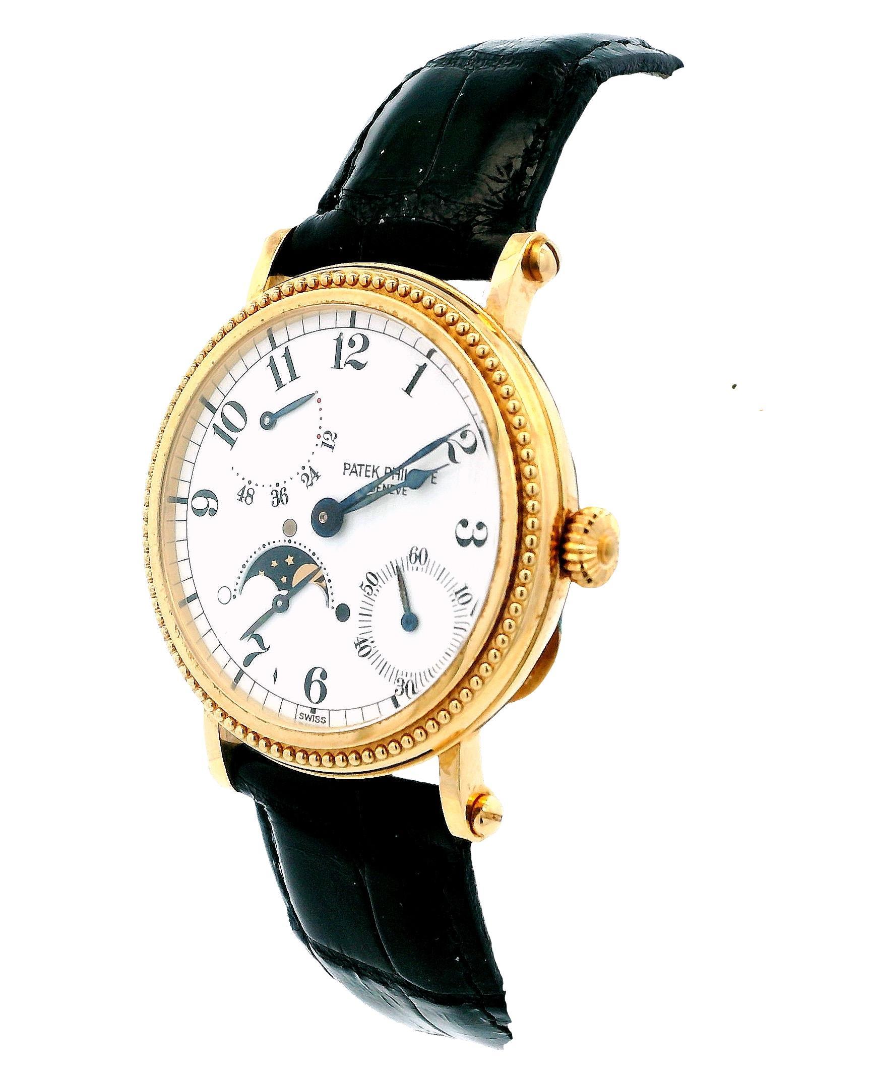 Patek Philippe Complications Men's Watch. This elegant timepiece features a 35mm case and bezel made of 18K yellow gold. The white dial is complemented by black hands and Arabic numeral hour markers. A moon phase indicator is positioned between the