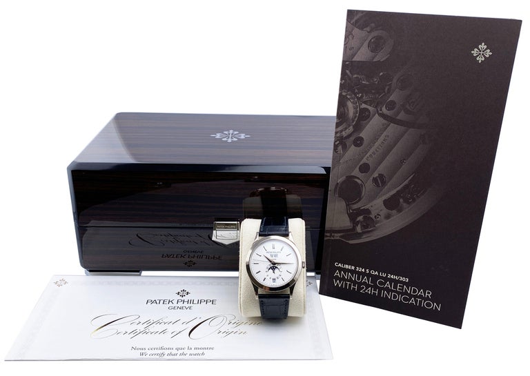 Patek Philippe Complications 5396G-011 Mens Watch. 38.5mm 18K white gold case and 18K white gold bezel. Silver dial with luminous white gold hands and white gold index hour markers. Annual calendar displays with a moon phase indicator. Black leather