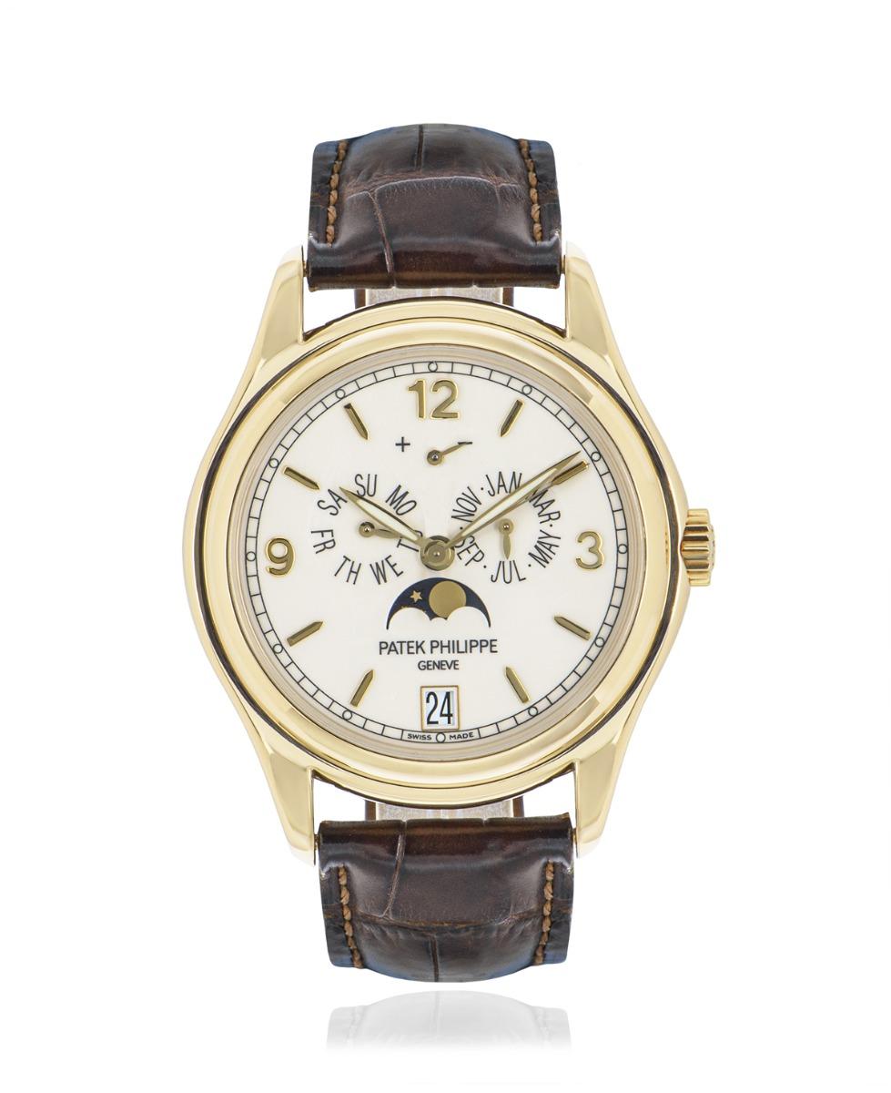 A Complications 39mm Annual Calendar in yellow gold by Patek Philippe. Featuring a cream dial with displays of the day, date and month. The dial also features has a moon phase display and a power reserve indicator.

The original brown leather strap