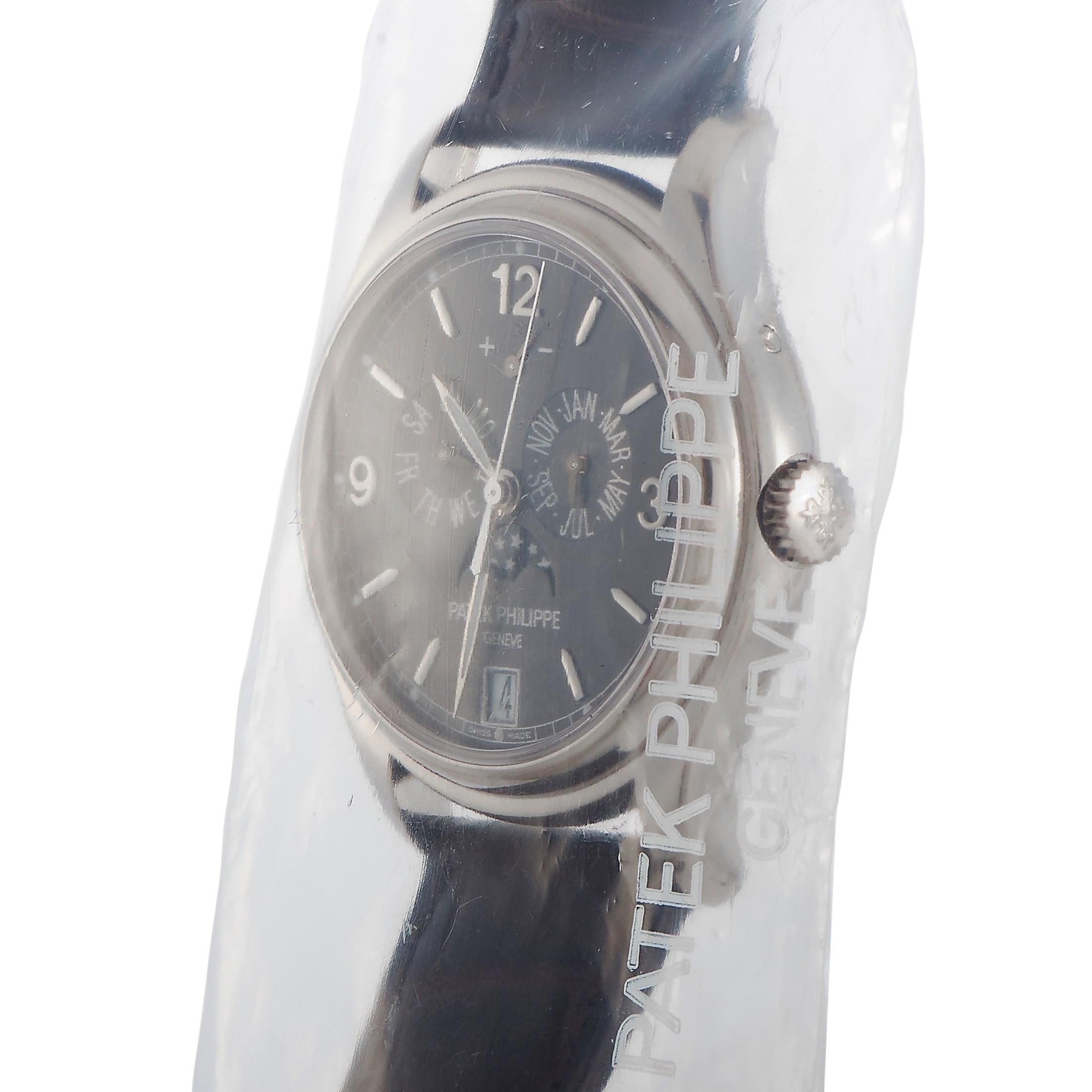 This Patek Philippe Complications Annual Calendar, Moon Phases 39mm Watch, reference number 5146G-010, has a case that is crafted from 18K white gold and measures 39 mm in diameter. The case is presented on a black hand stitched crocodile leather
