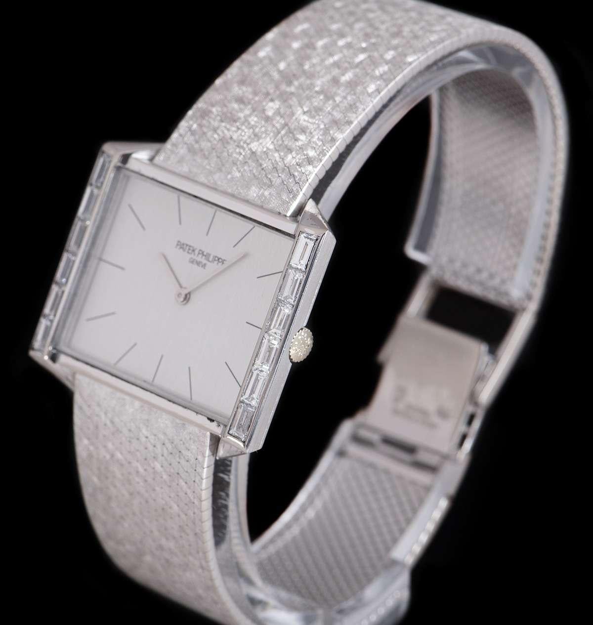 A 29.5 mm 18kWhite Gold Vintage Mid-SizeDress Wristwatch, silver dial with hour markers, a fixed18kwhite gold bezel set with 12 baguette cut diamonds (~1.3ct), an18kwhite gold integrated bracelet with an18kwhite gold jewellery style clasp,