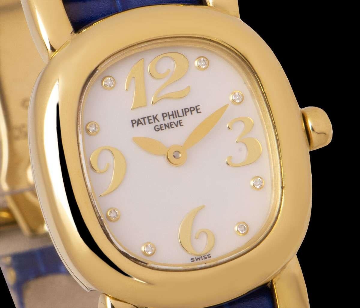An 18k Yellow Gold Ellipse Ladies Wristwatch, mother of pearl dial with applied arabic numbers 3, 6, 9, 12 and 8 applied round brilliant cut diamond hour markers, a fixed 18k yellow gold bezel, an original blue leather strap with an original 18k