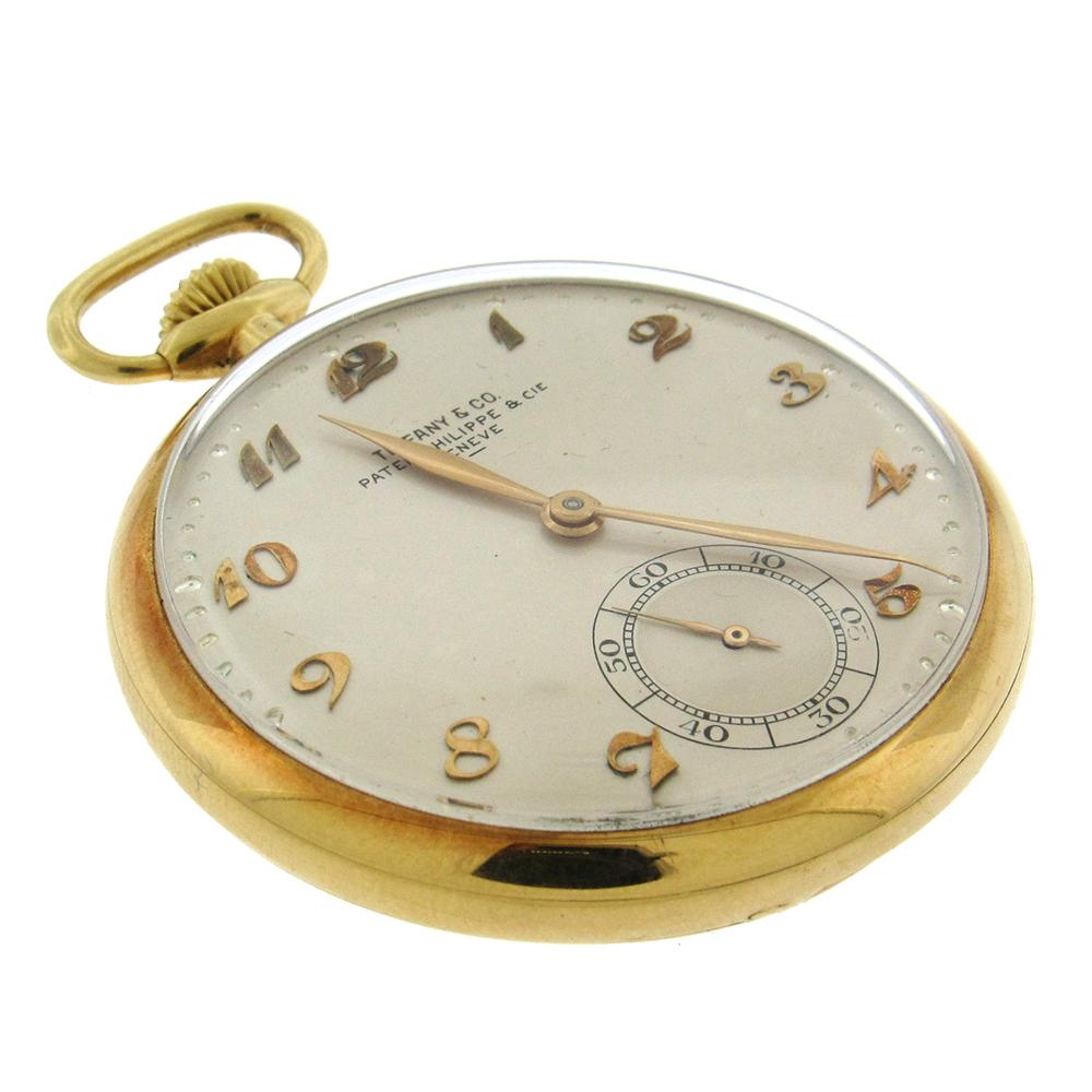 18K yellow gold Patek Philippe pocket watch made for Tiffany & Co in the 1930's, is an open face 46mm pocket watch polished back, matte silver dial with applied gold Breguet numerals and subsidiary seconds, gold leaf hands. The 18 jewel movement is
