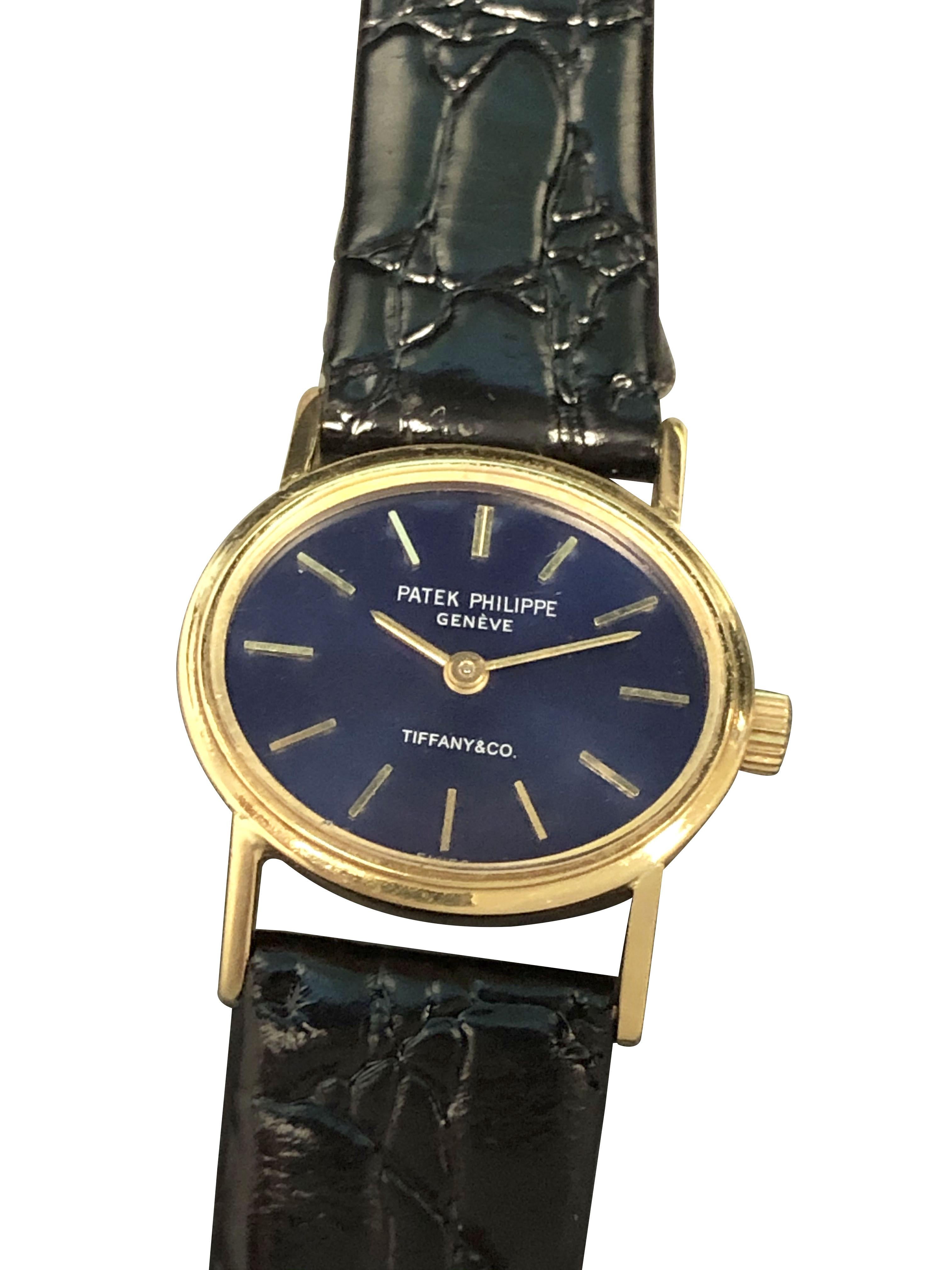 Circa 1990 Patek Philippe Reference 3349 Elipse Retailed by Tiffany & Company,  22 X 19 M.M. 18K Yellow Gold 2 piece case, 20 Jewel Mechanical, Manual wind Nickle Lever movement. Blue Dial with Raised Gold markers. New Black Croco grain strap.