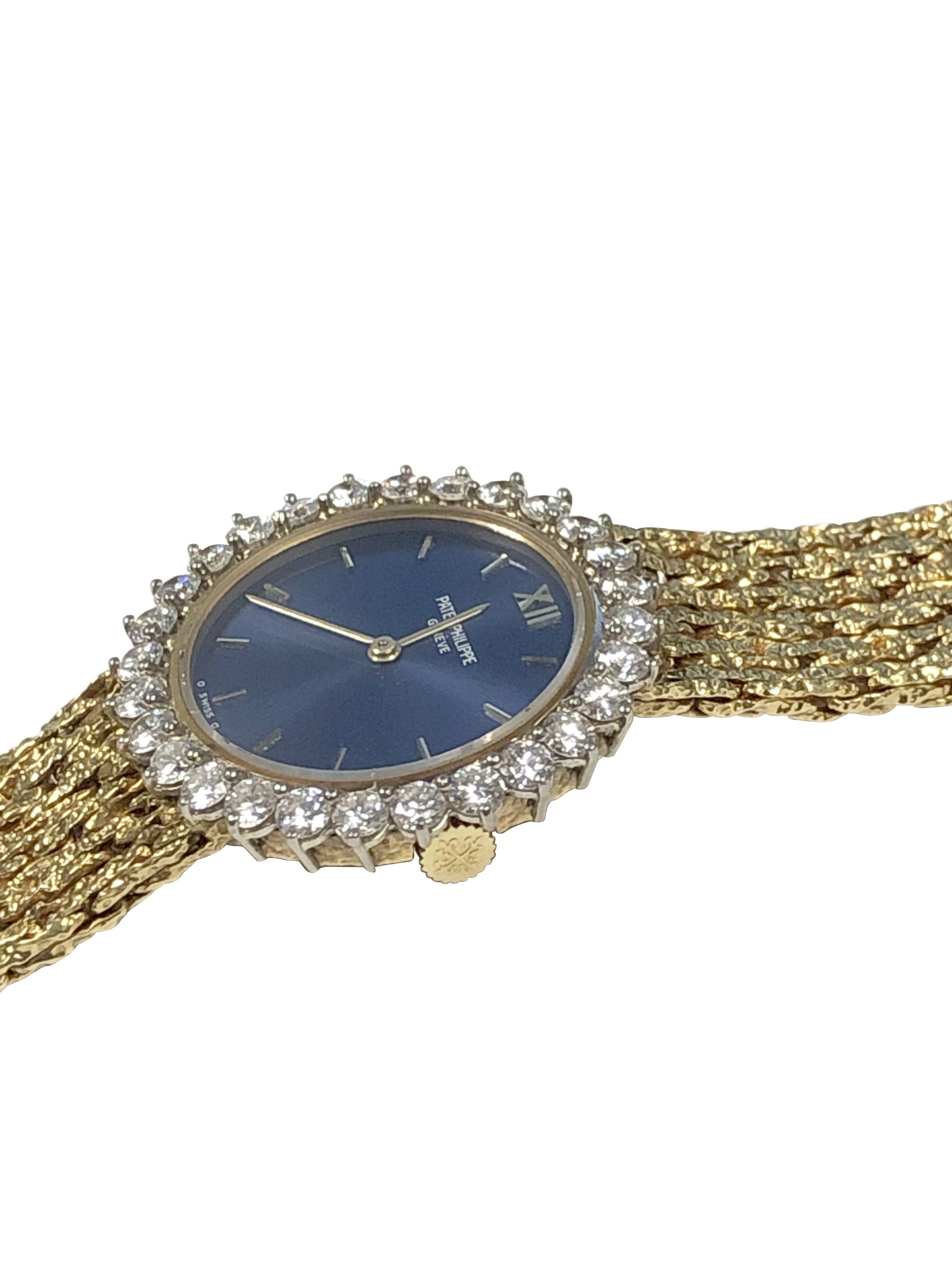 Circa 1970s Patek Philippe Ladies Wrist Watch, 26 M.M. 18K Yellow Gold 2 Piece case with White Gold bezel Factory set with Round Brilliant cut Diamonds totaling 1.50 Carats, 18 Jewel Mechanical, manual wind movement. Blue Satin dial with Raised Gold