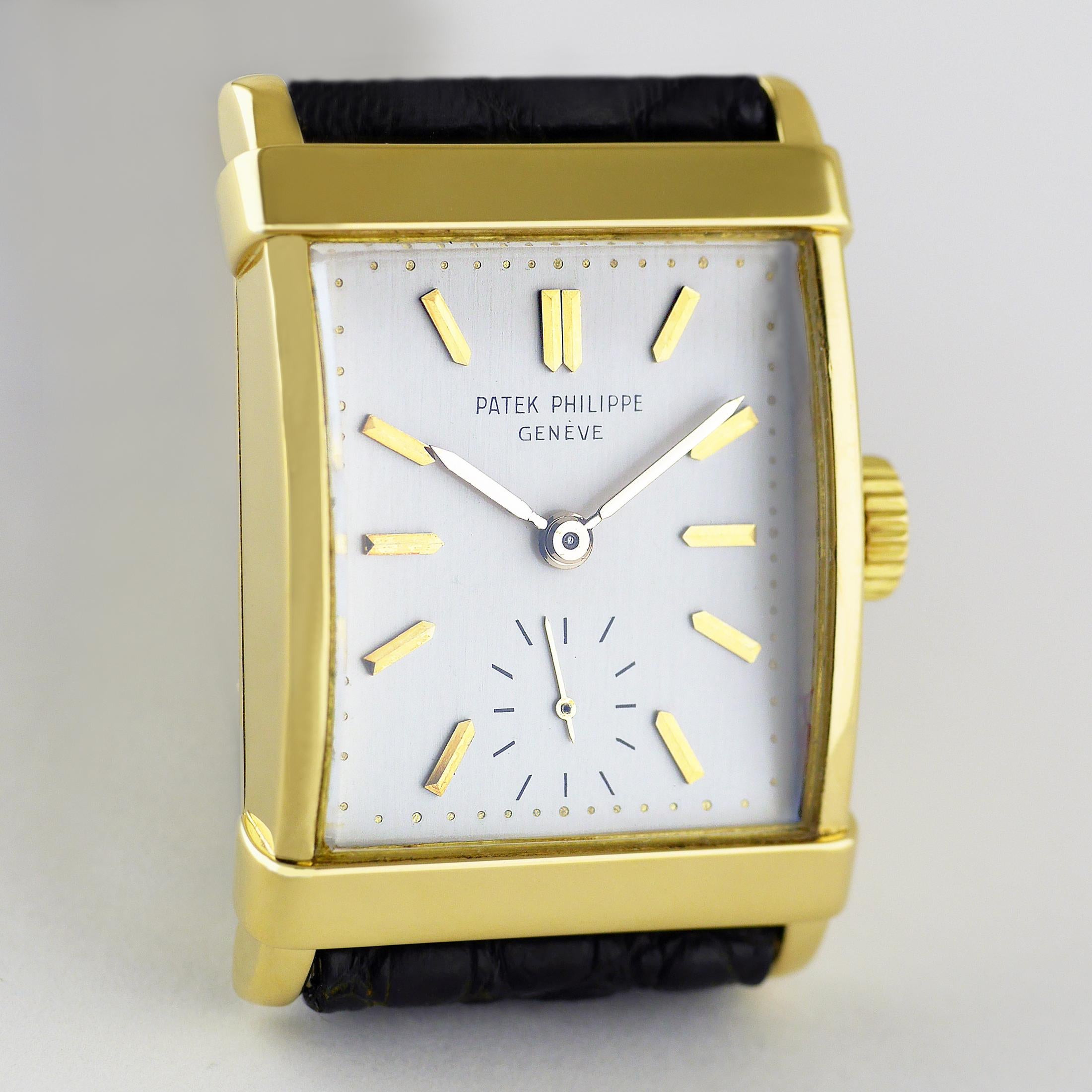 Eine elegante, feine und seltene Vintage-Armbanduhr von Patek Philippe aus dem Jahr 1964.

Das rechteckige 18-Karat-Gehäuse aus Gelbgold mit überlagertem, gestuftem Band an der oberen und unteren Lünette und verjüngten Bandanstößen.

Jewelled,